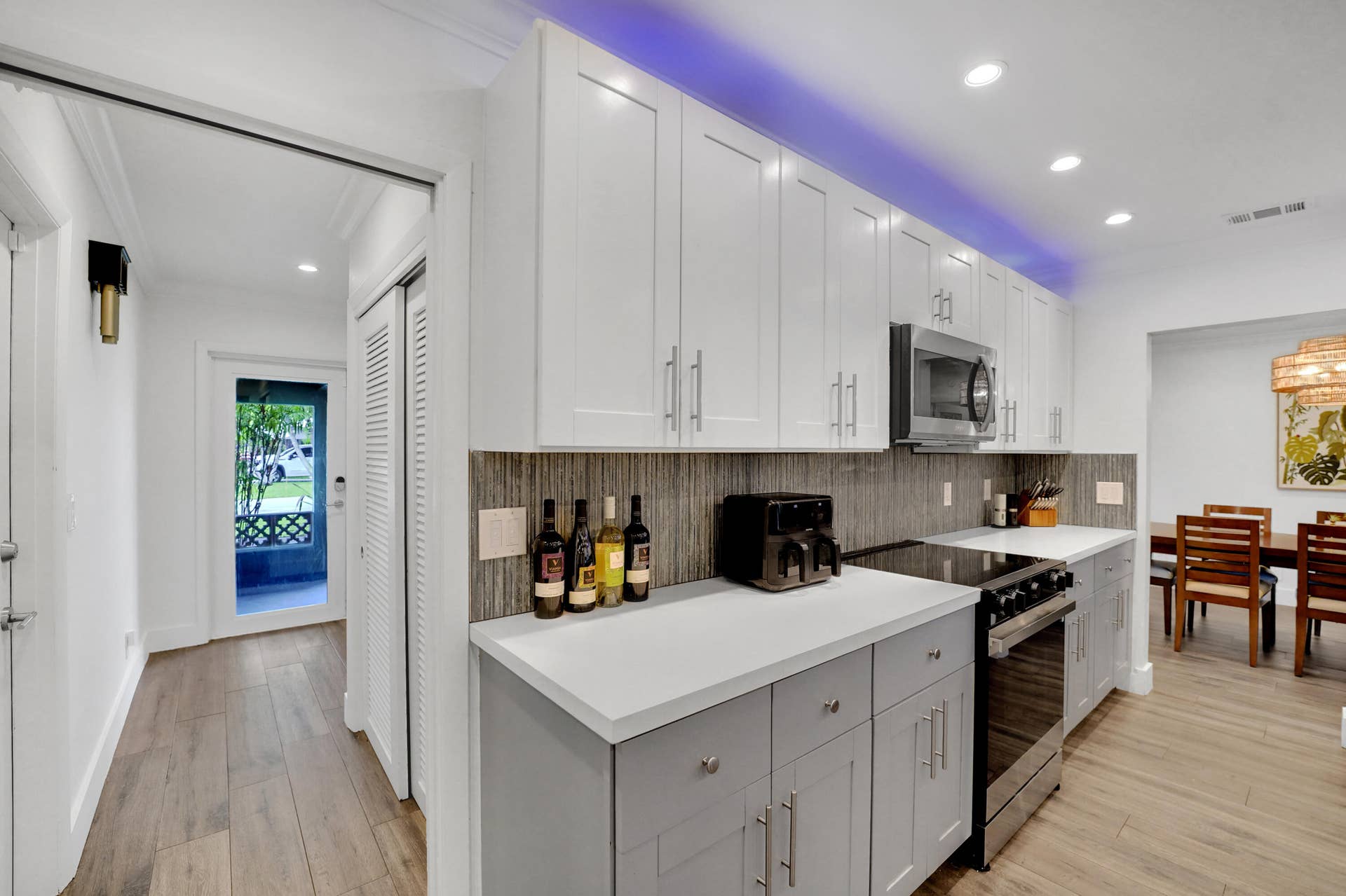 380 NW 35TH Court, Oakland Park, FL 33309 Kitchen featuring white upper cabinetry, grey base cabinetry, solid-surface countertops, textured tile backsplash, and recessed lighting
