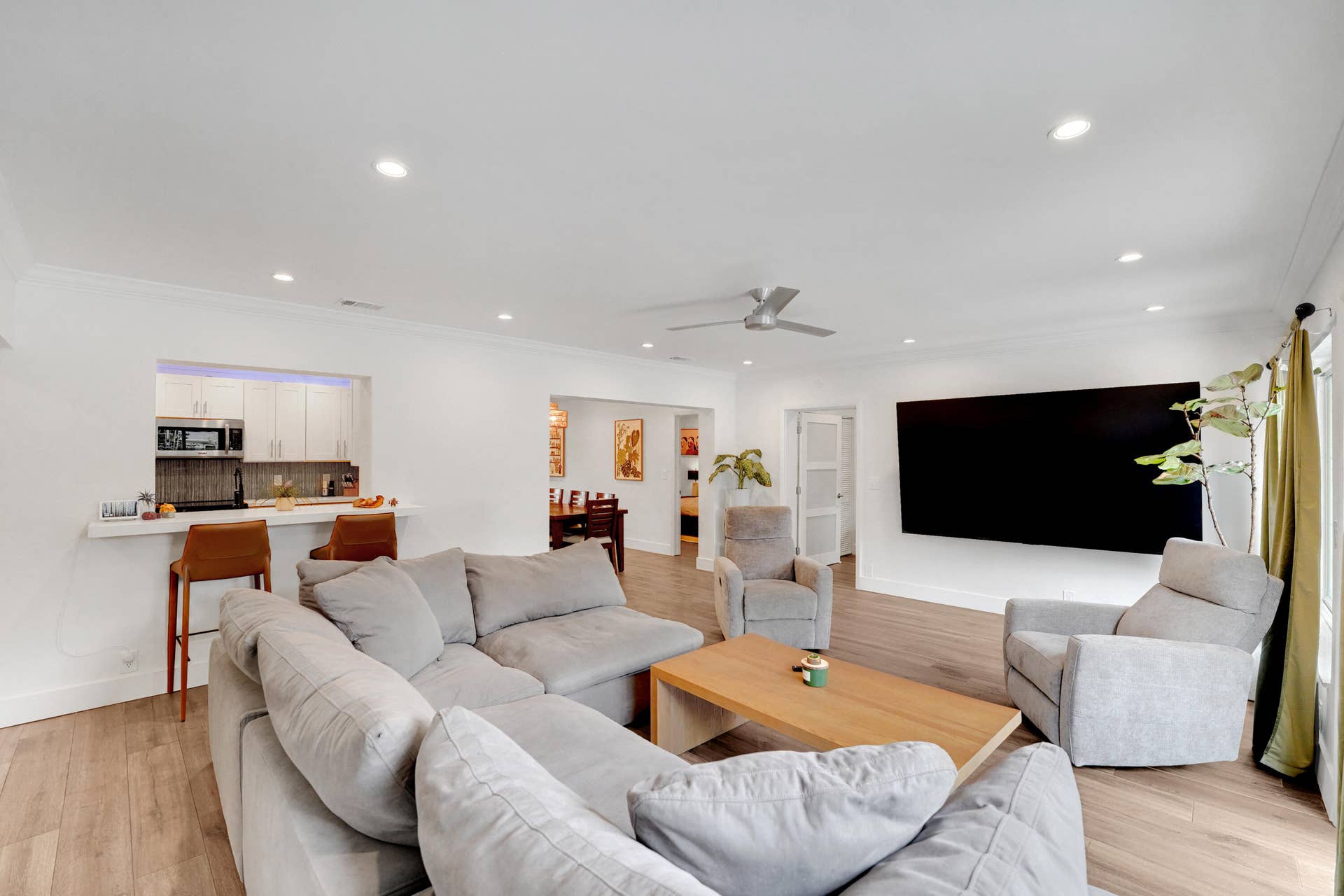 380 NW 35TH Court, Oakland Park, FL 33309 Open-concept living space recessed lighting, crown molding, a ceiling fan, and a breakfast bar with built-in cabinetry