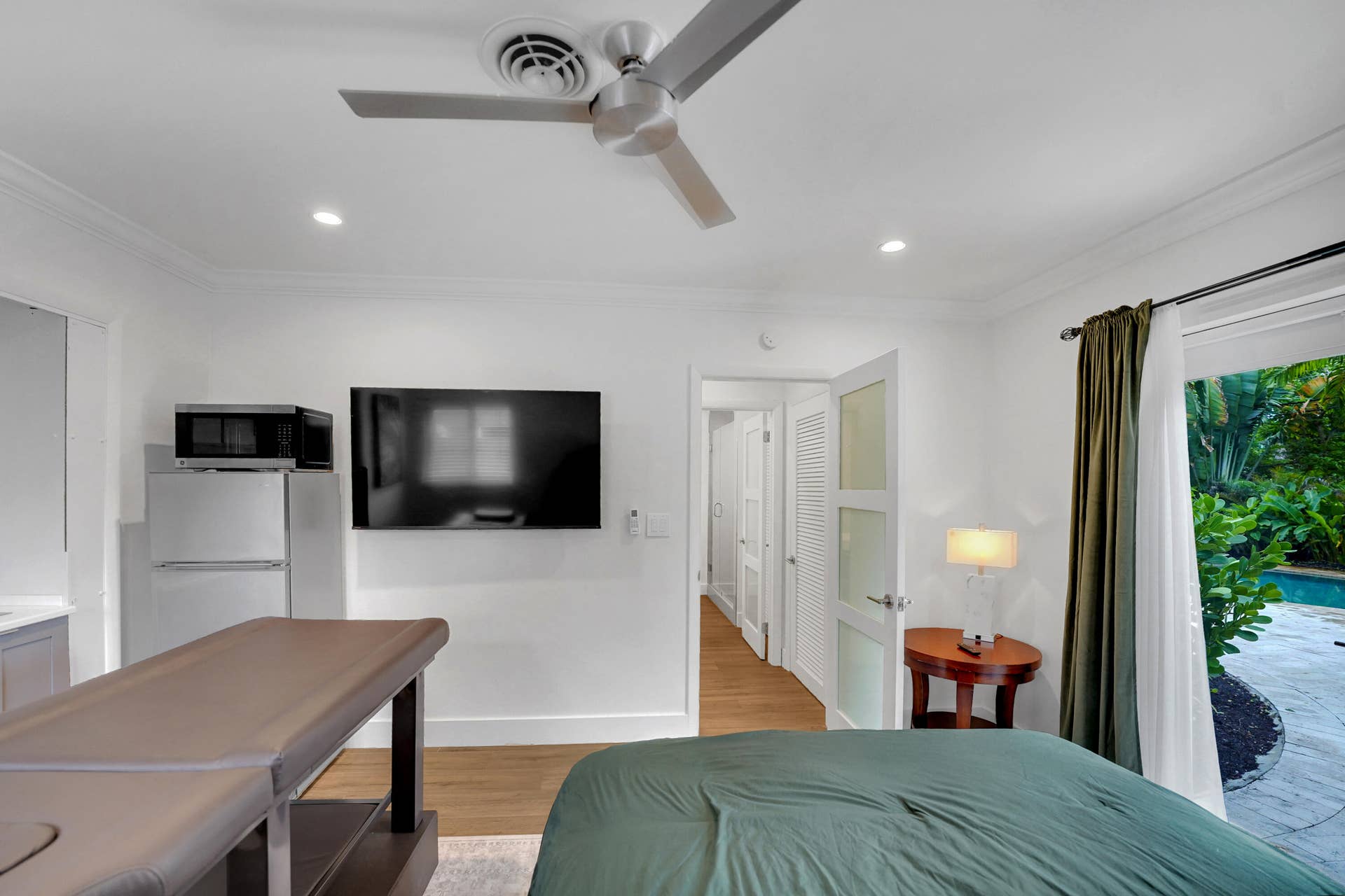 380 NW 35TH Court, Oakland Park, FL 33309 Modern interior featuring wood-finish flooring, recessed lighting, a ceiling fan with integrated lighting, and a glass-paneled entry door