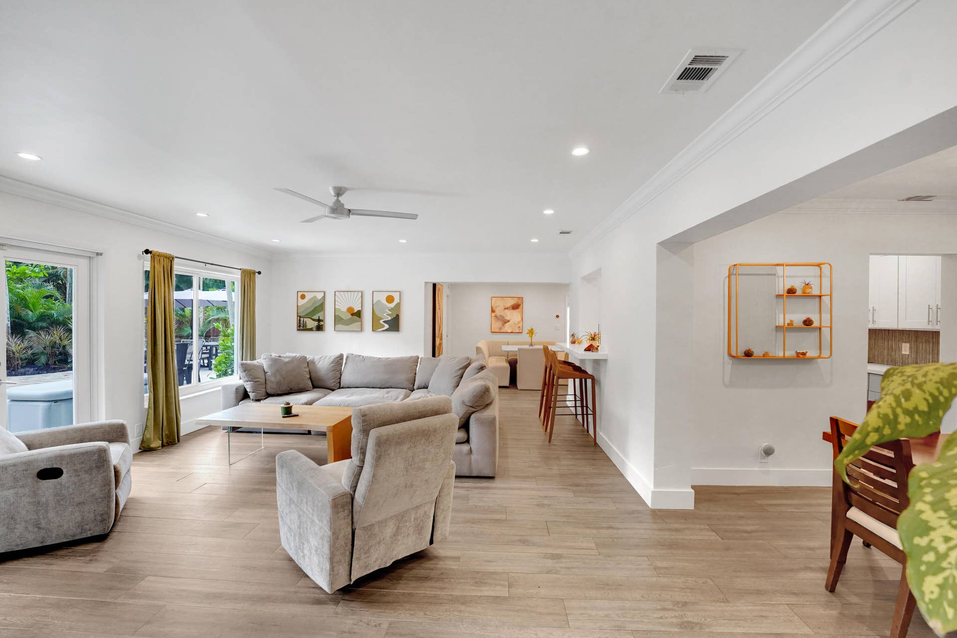 380 NW 35TH Court, Oakland Park, FL 33309 Open-concept living space featuring wood-finish flooring, recessed lighting, crown molding, a ceiling fan, and a built-in breakfast bar