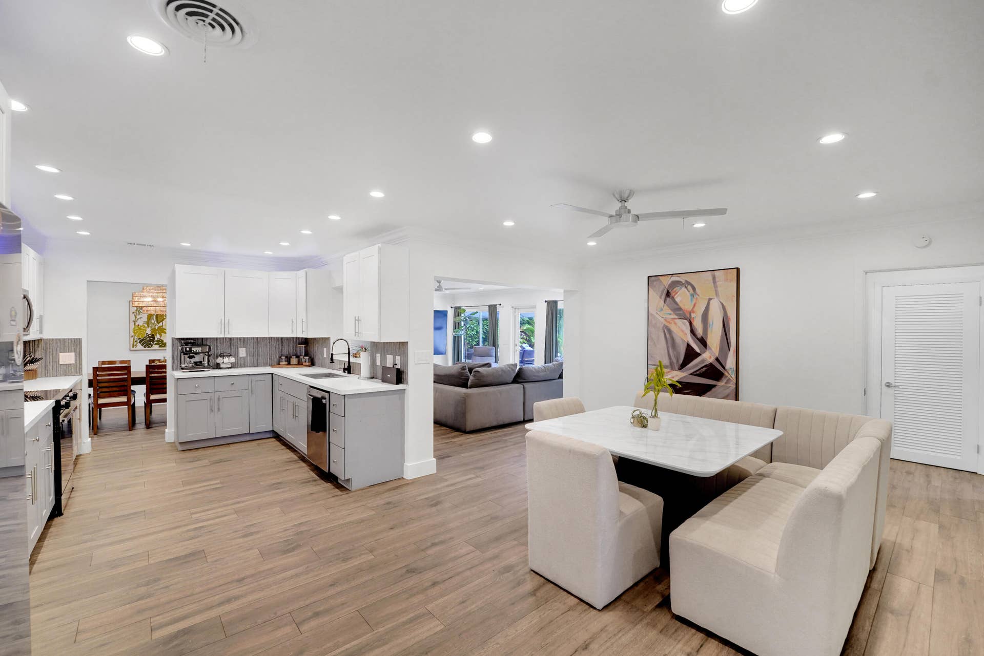 380 NW 35TH Court, Oakland Park, FL 33309 Open-concept kitchen featuring two-tone cabinetry, stone-finish countertops, recessed lighting.