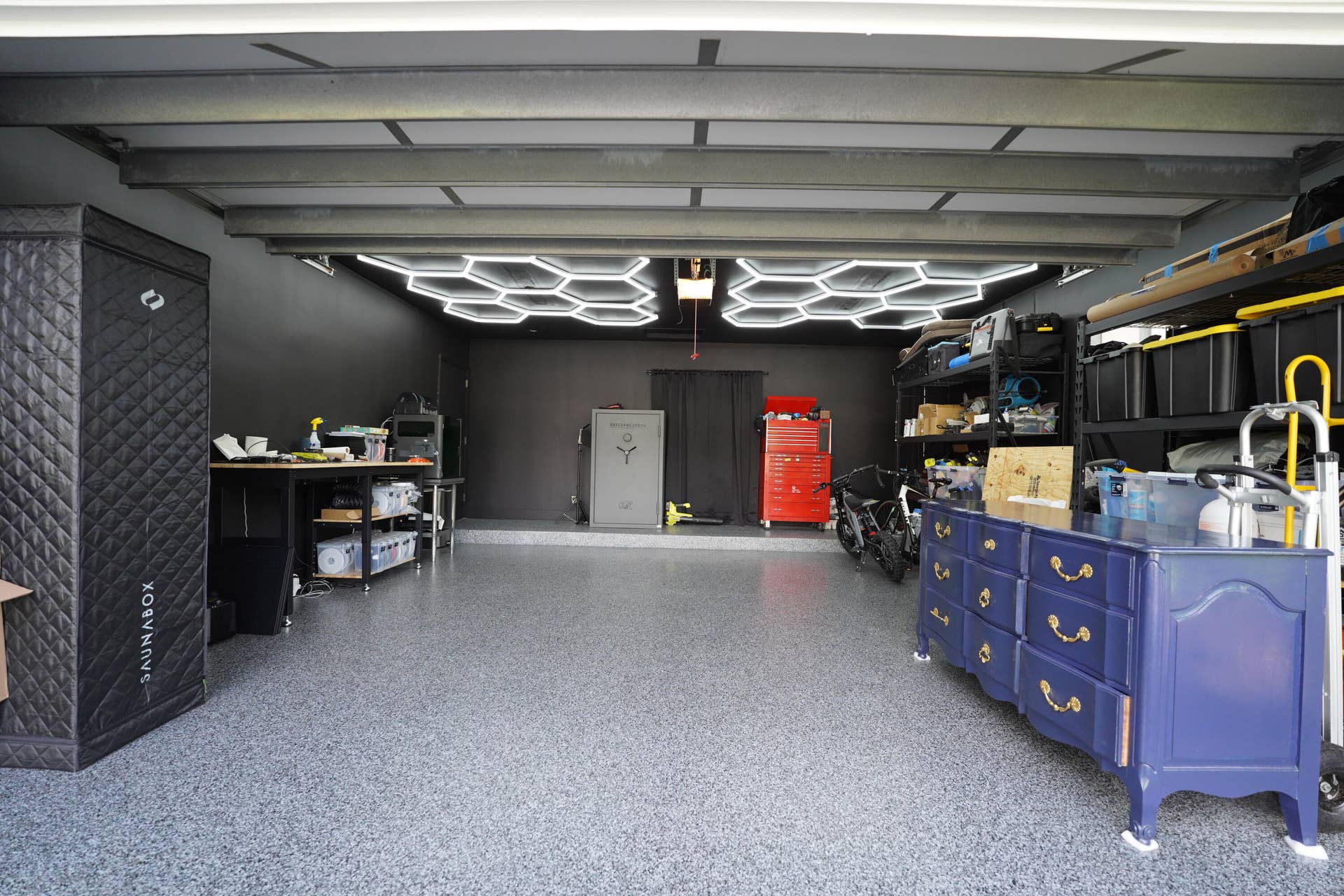 380 NW 35TH Court, Oakland Park, FL 33309 Garage featuring epoxy-coated flooring, matte black wall finishes, and geometric LED ceiling lighting