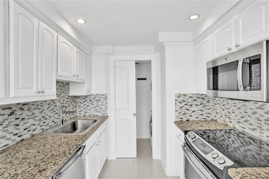 3400 Galt Ocean Drive, #1509 S, Fort Lauderdale, FL 33308 A pocket door closes off the laundry room from the rest of the kitchen. There is cabinet storage space inside the laundry room.