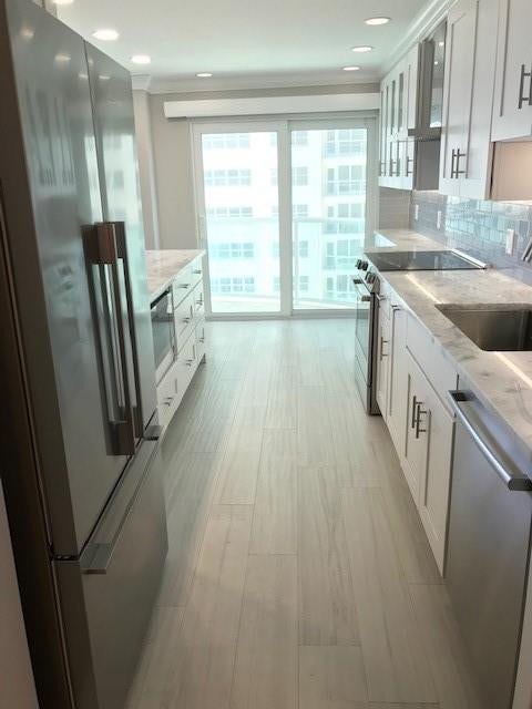 The entry into the kitchen from the dining room. The french door refrigerator is Fisher & Paykel. The microwave to the right of the refrigerator is LG