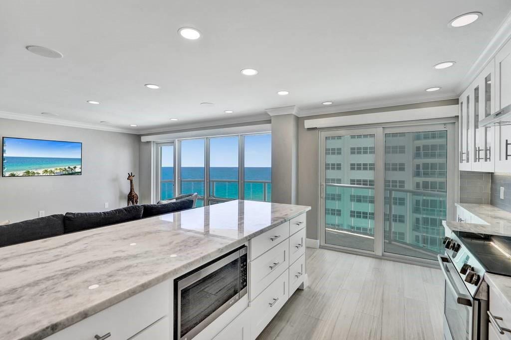The wall was removed, resulting in an open kitchen. It is appointed with beautiful quartz countertops and high end stainless steel appliances.