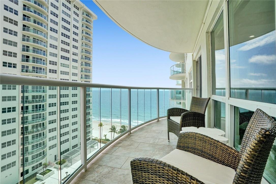 The east facing balcony has impact glass panels. The two wicker chairs and the table do not convey with the sale. This apartment is the 3rd one in from the oceanfront corner. The large heated pool is directly beneath. It is currently under renovation.
