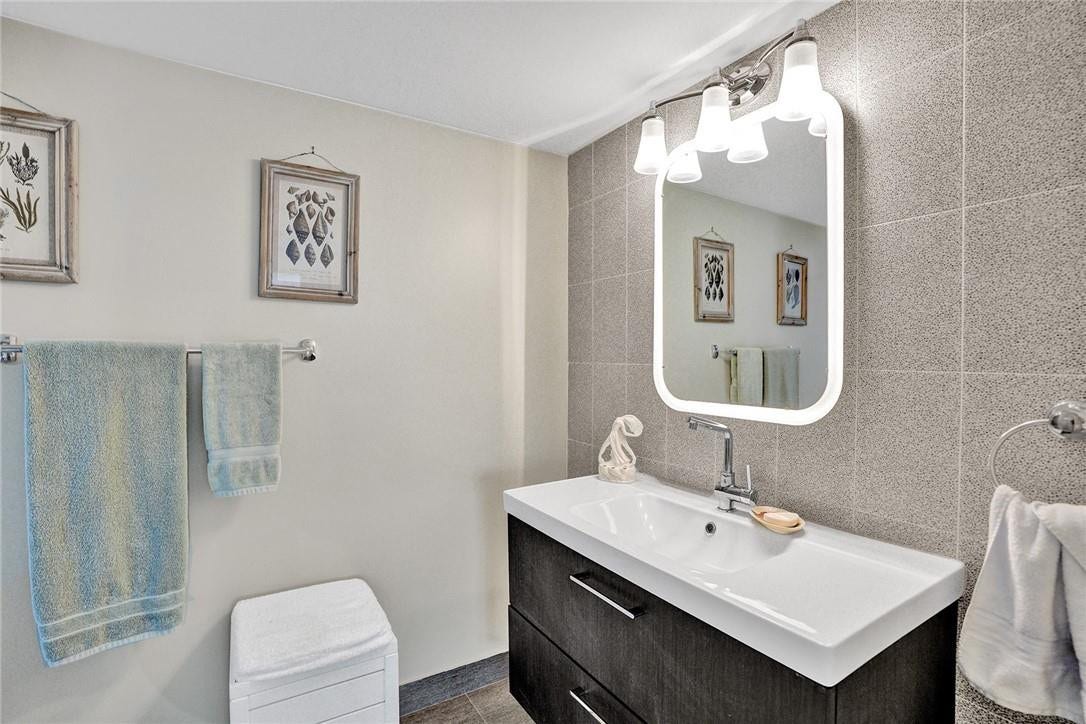 The primary bathroom has a floating vanity and a tiled accent wall. The 3 pictures do not convey with the sale. The owner will also be taking all towels, sheets and linens.