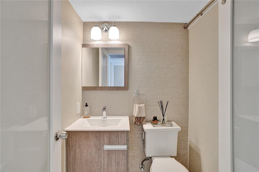 The half bathroom has a floating vanity and designer textured tile on the wall behind the vanity.