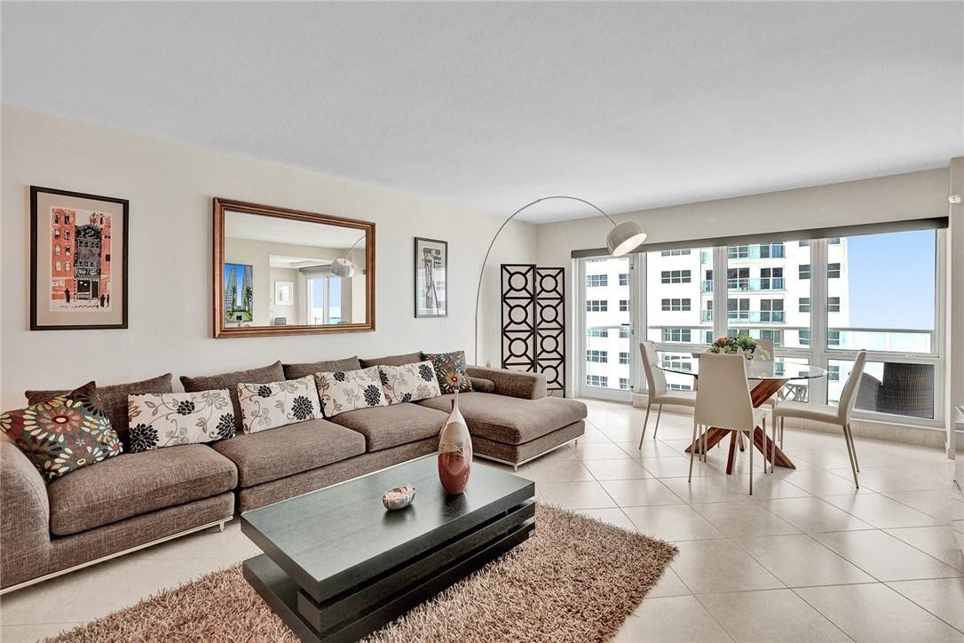 The round glass table in the living room is typically in the kitchen. The two photos on either side of the mirror are excluded from the sale.