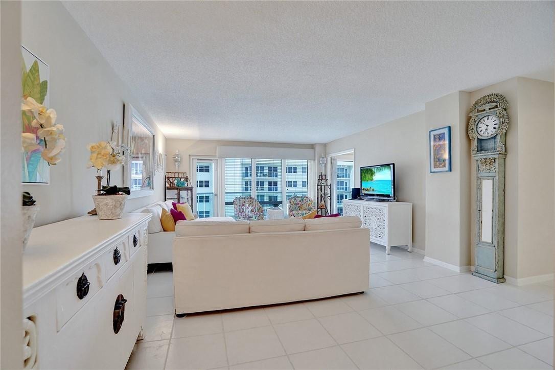 This is a spacious, bright living room. The door to the left of the 3 windows leads out onto the balcony. The doorway to the right of the 3 windows leads into the kitchen.