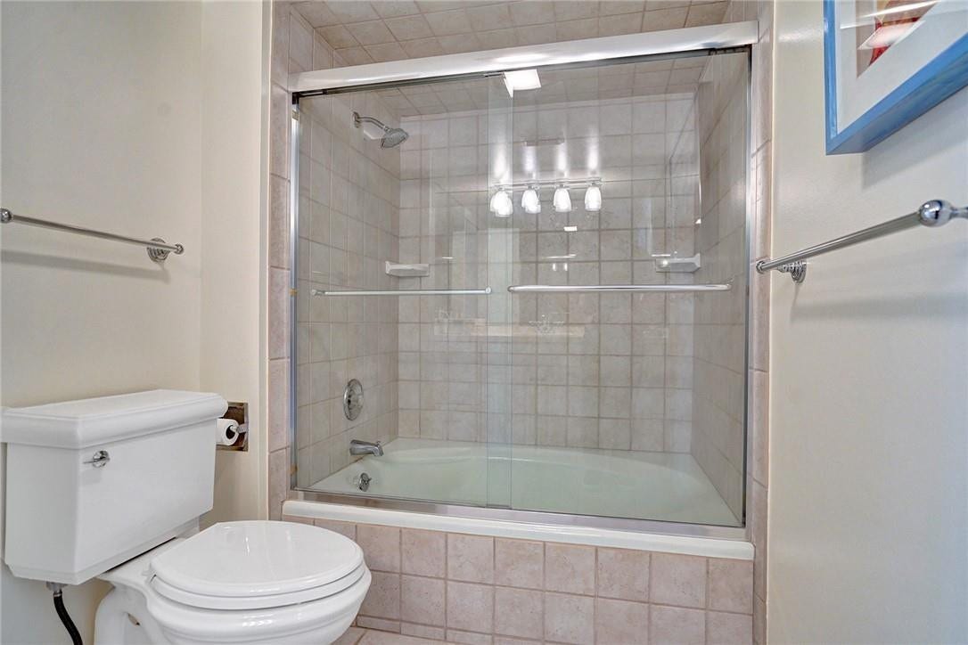 The primary bathroom has a tub and a glass enclosed shower. The floor tile in here matches the tile around the tub area.