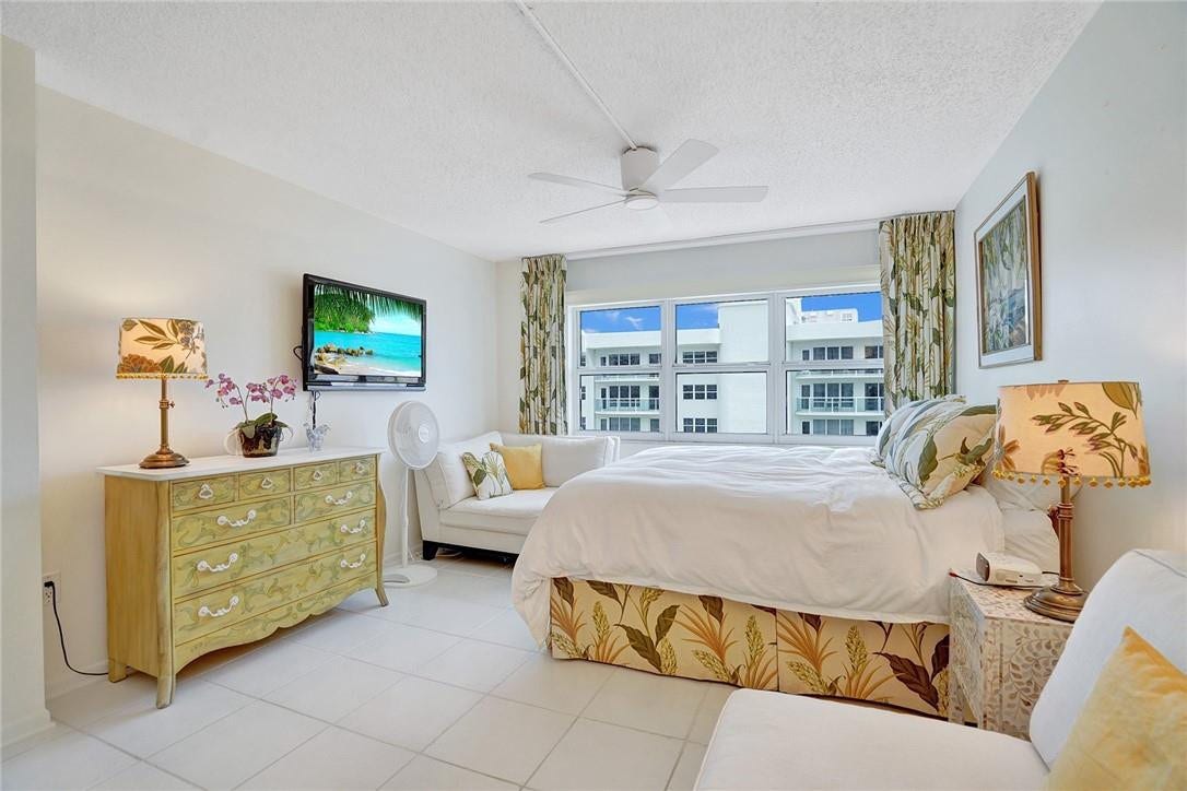 The tropical decor continues into this roomy primary bedroom. A ceiling fan keeps things cool.