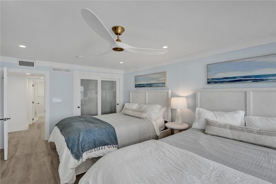 The second bedroom houses has a closet behind the two sliding glass doors. You can catch a peek of the second bathroom. Note the stunning ceiling fan.