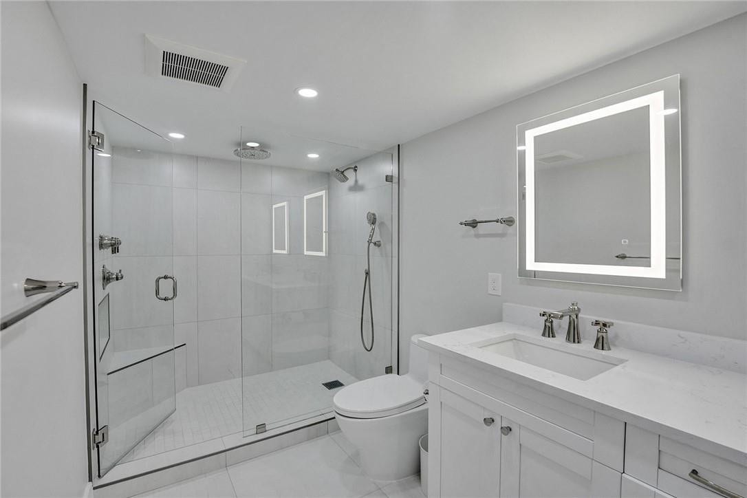 The primary bathroom has a glass enclosed shower area with a rain head. I love that the glass shower door opens both ways, both into the shower area and and out. And I really, really love that the owners put the faucets/controls on the opposite wall of the shower area, so you do not get a head full of water when you turn on the shower. The shower control has 3 functions.