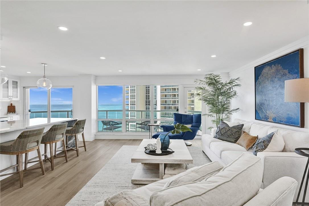 There are two ways to access the balcony: an impact glass door, which is behind the blue chair, and the sliding glass door in the kitchen.