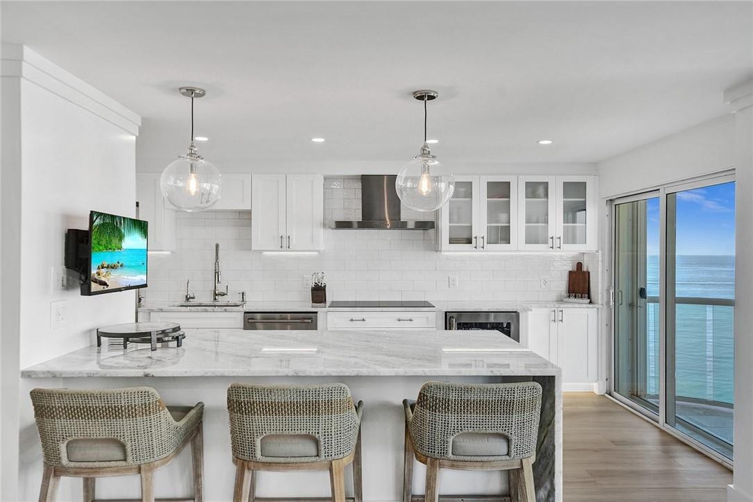 The kitchen features top of the line appliances (still under warranty), quartzite counter tops, with a waterfall finish on the eat in counter, a wine cooler/refrigerator to the right of the stove, extra storage under the eat in counter top (facing the sink), above counter lighting, recessed lighting, and under cabinet and toe kick lighting.