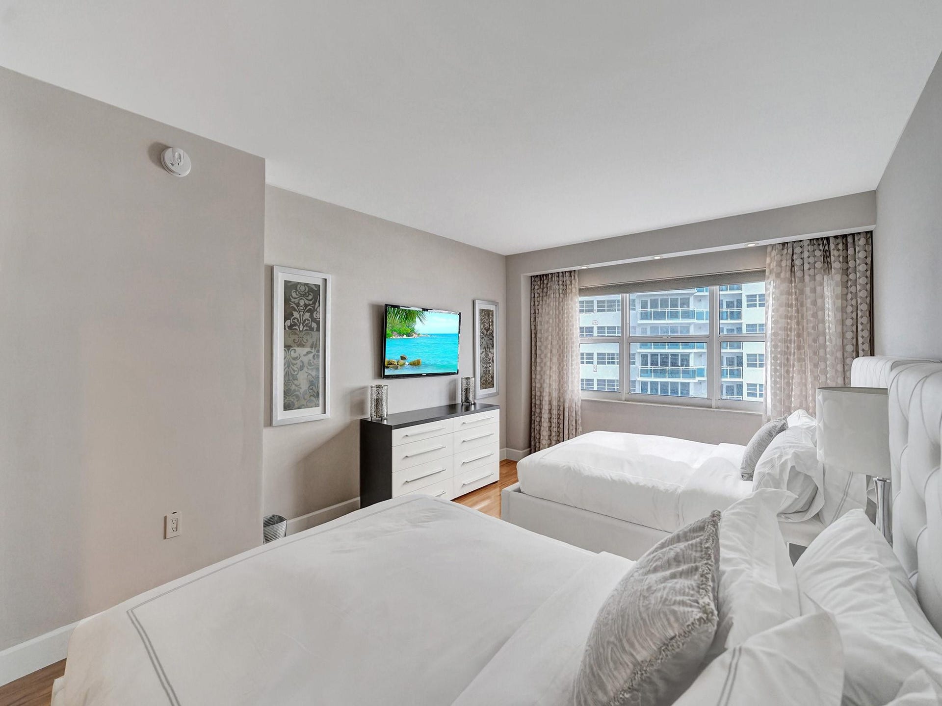 The guest bedroom has custom window treatments, including a black out shade.