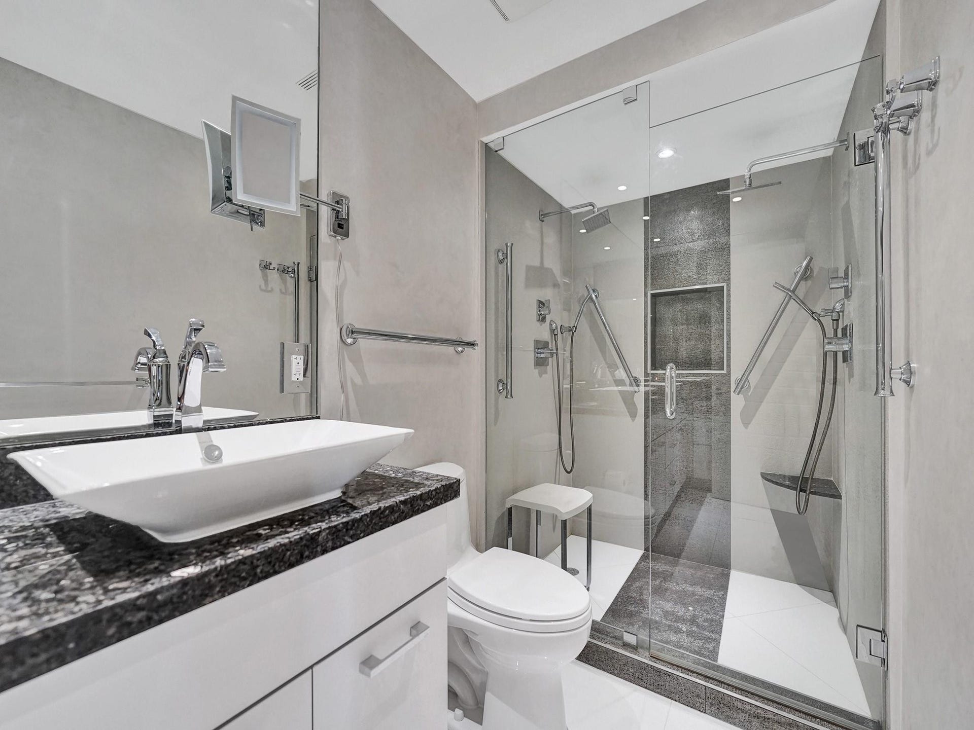 The roomy walk in shower has frameless glass doors, 2 shower heads and Delta hardware.