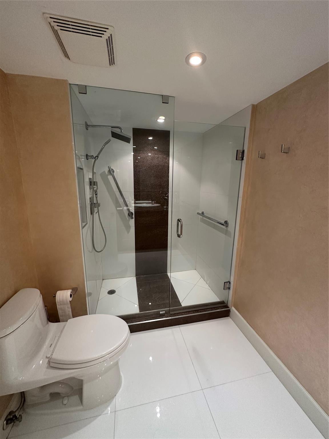 The guest bathroom has frameless glass shower doors.
