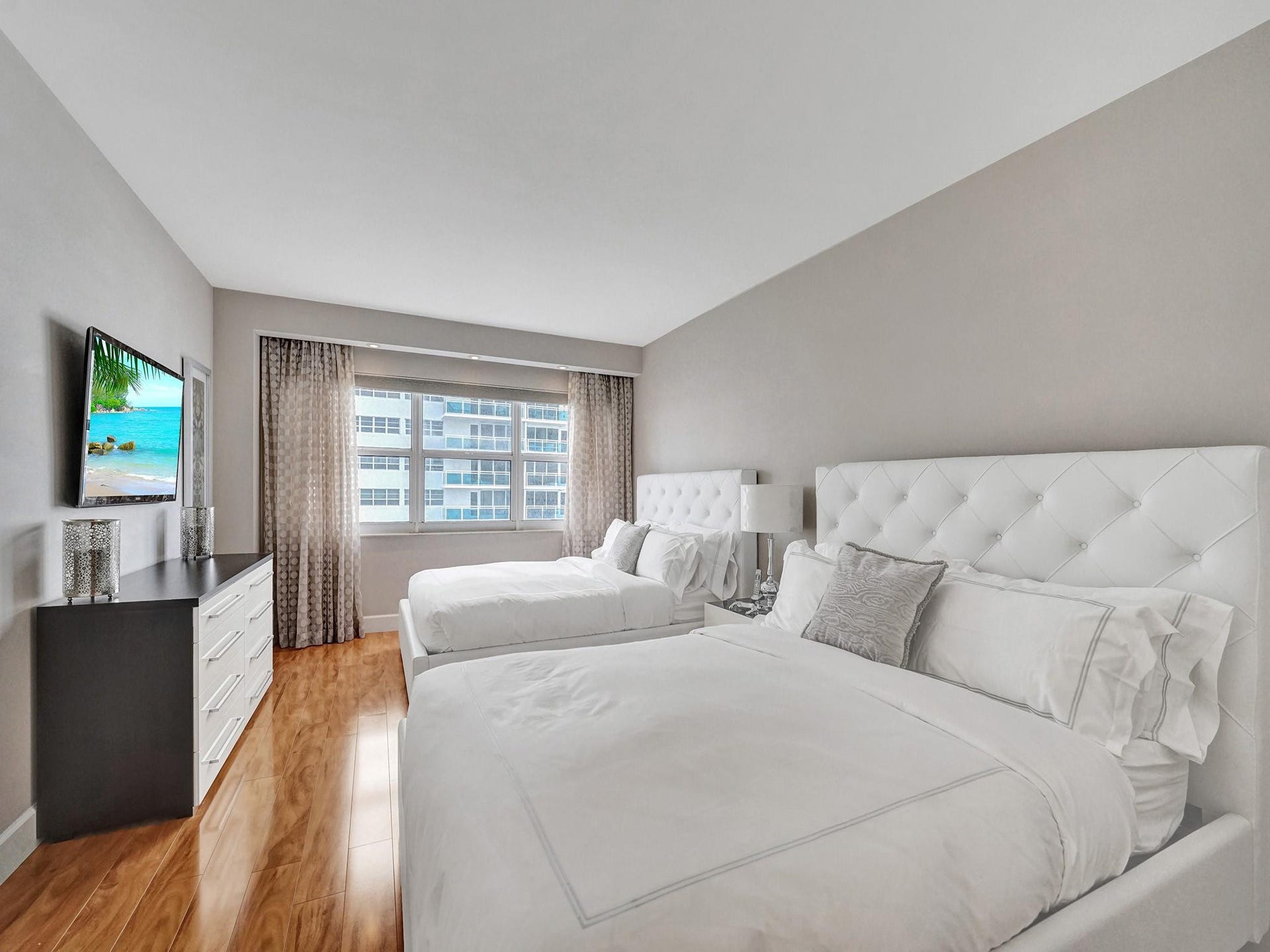 The guest bedroom features the same lovely engineered wood floor as the primary bedroom.