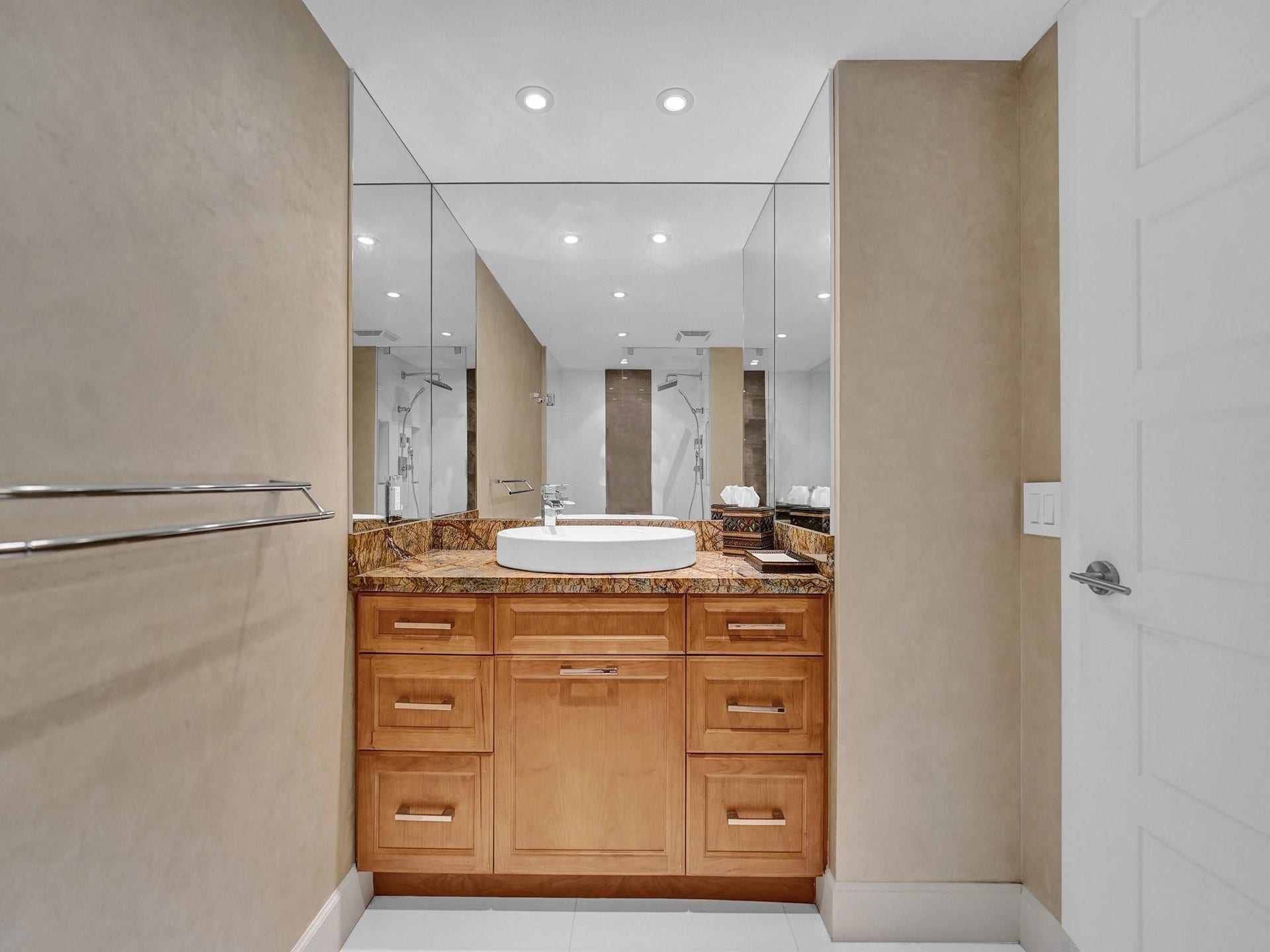 The guest bathroom has a custom vanity and a granite countertop.