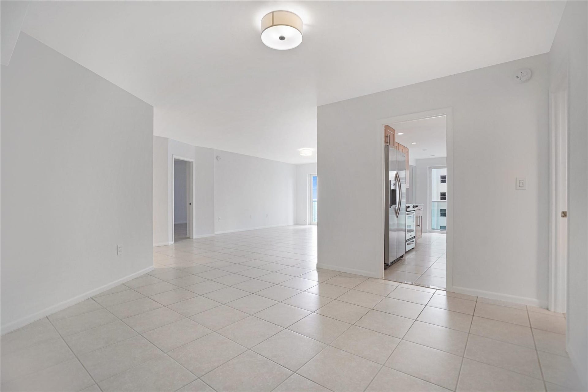 The dining room has entry into the kitchen. The doorway to the left is the primary bedroom. The second bedroom doorway is to the right of the kitchen and the dining room.