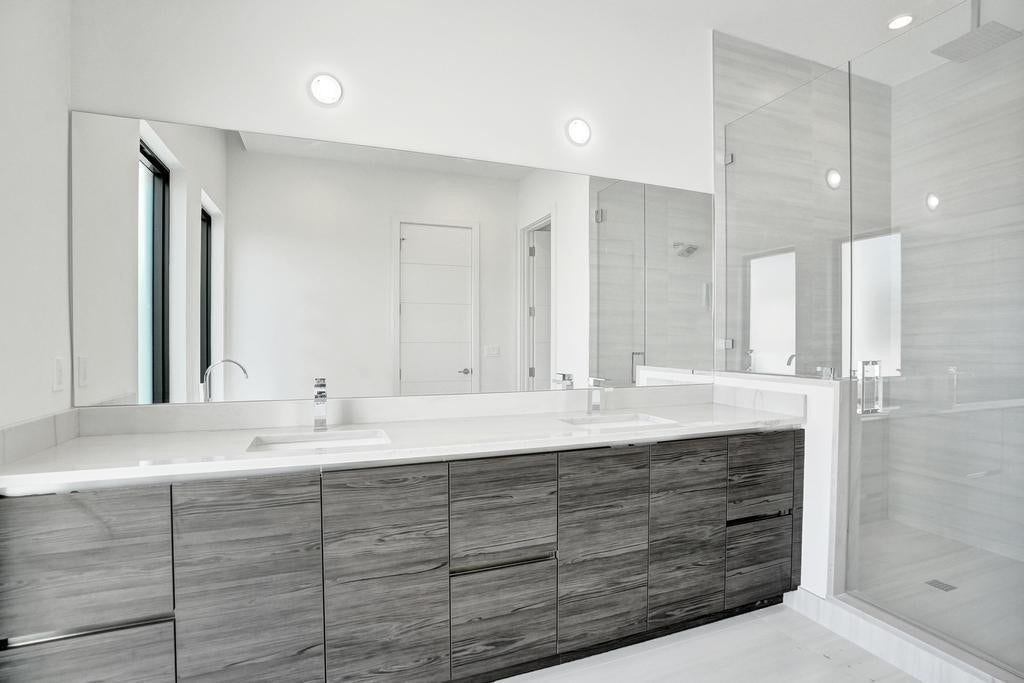 Primary Bath Detail  Dual vanities with custom cabinetry, designer fixtures, and a beautifully designed shower enhanced by an optional overhead rain feature for a spa-like experience.  Pre-wired for buyer-selected vanity lighting.