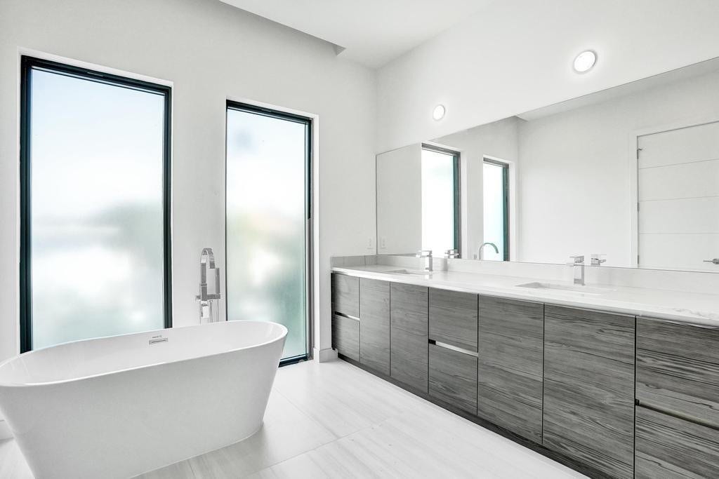 Primary Bathroom  Spa-inspired retreat featuring custom cabinetry, dual vanities, beautifully designed shower , and a soaking tub filled with natural light. Perfect for unwinding together, enjoying a glass of wine in the tub, or creating a serene, at-home spa experience.