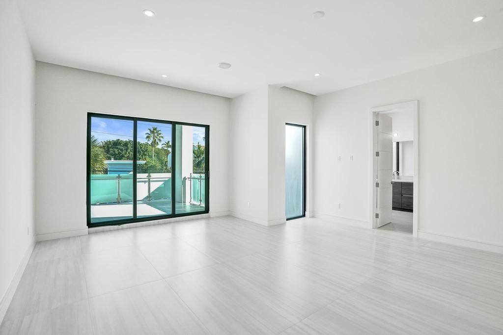 Primary Bedroom  Oversized suite with high ceilings, two walk-in closets, and an east-facing covered balcony large enough to serve as an outdoor living room. Balcony includes TV and spa connections and overlooks the pool.