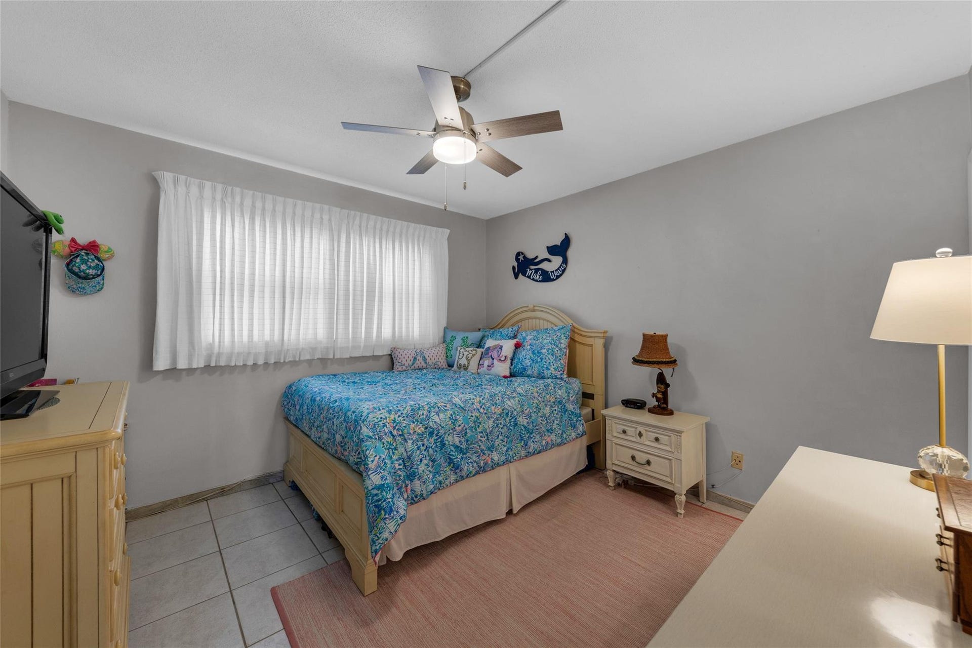 Master Bedroom is large and spacious with tile flooring and overhead ceiling fan with lighting