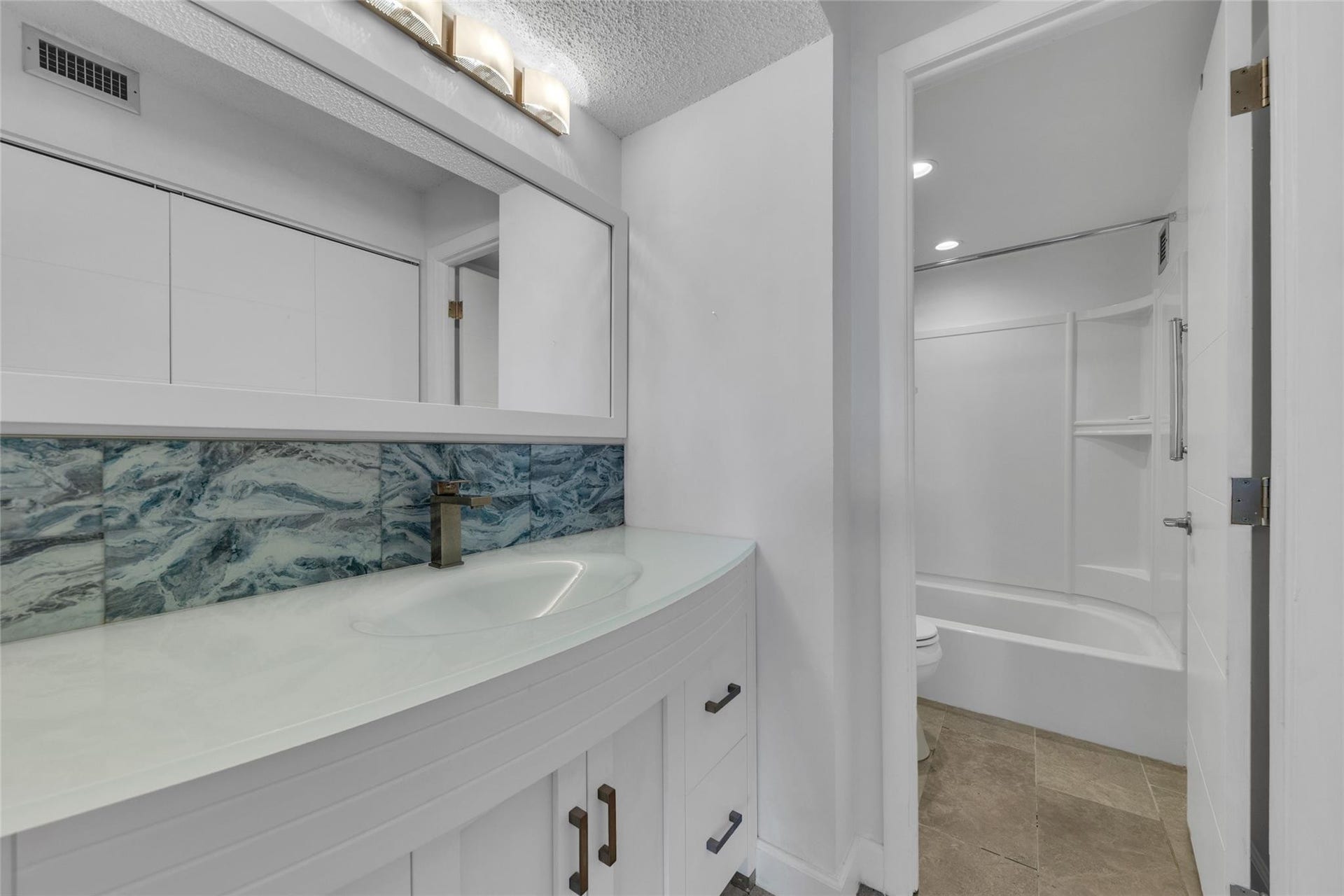 3015 N Ocean Boulevard, #9C, Fort Lauderdale, FL 33308 Beautifully remodeled Vanity and Dressing Area with combination tub and shower in view.