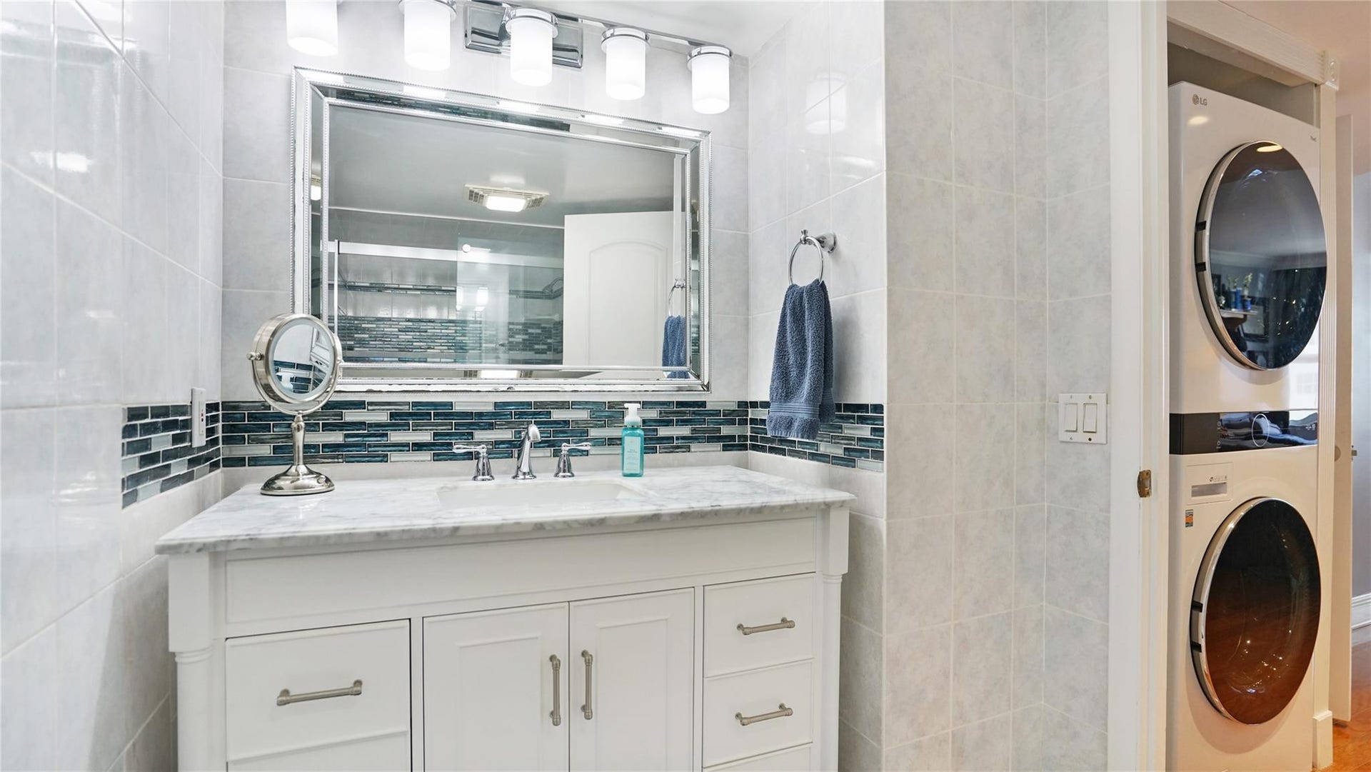 The beautiful neutral bathroom features a marble topped vanity.