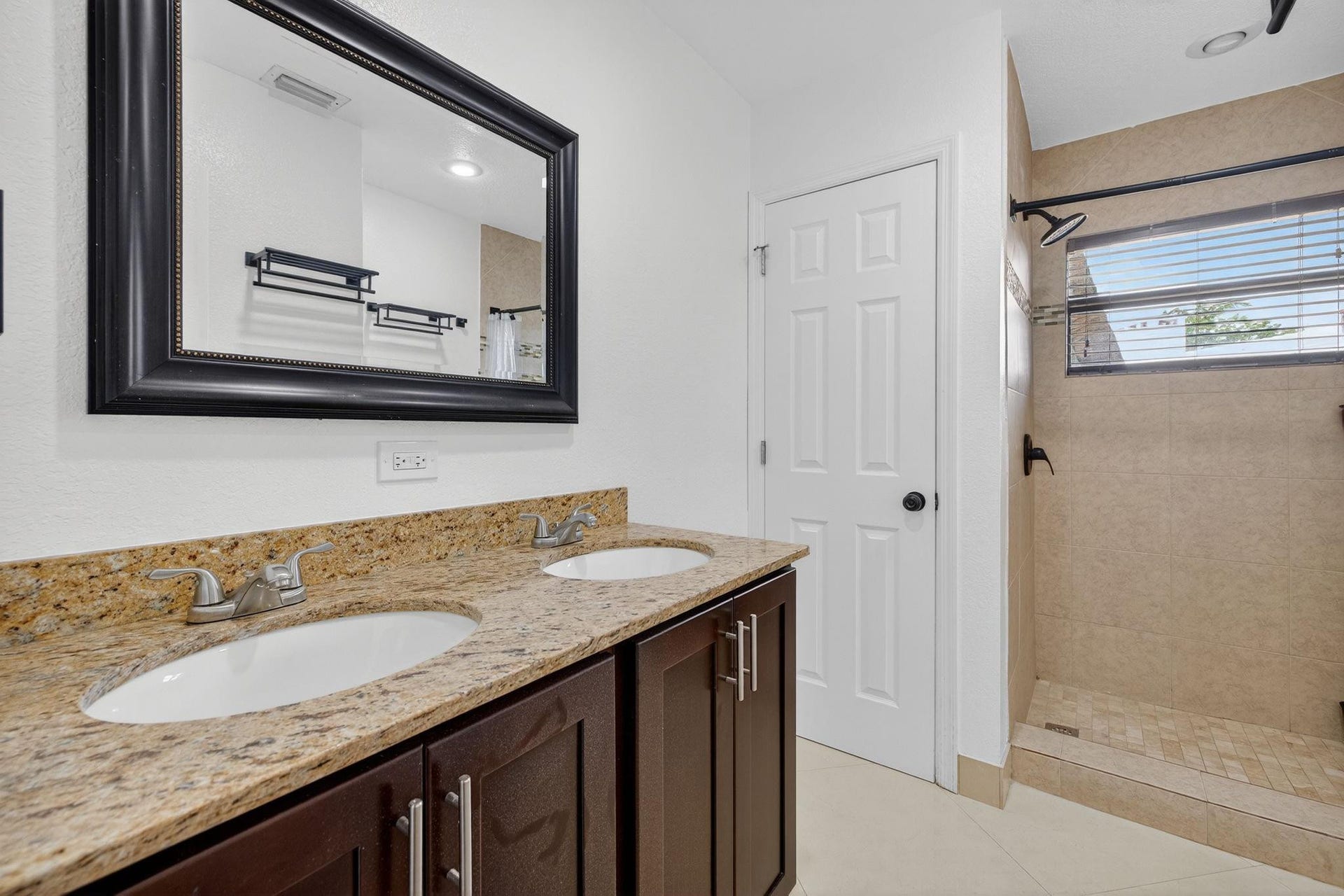 3rd Bathroom with dual vanity, standing shower and enclosed toilet area for added comfort and privacy.