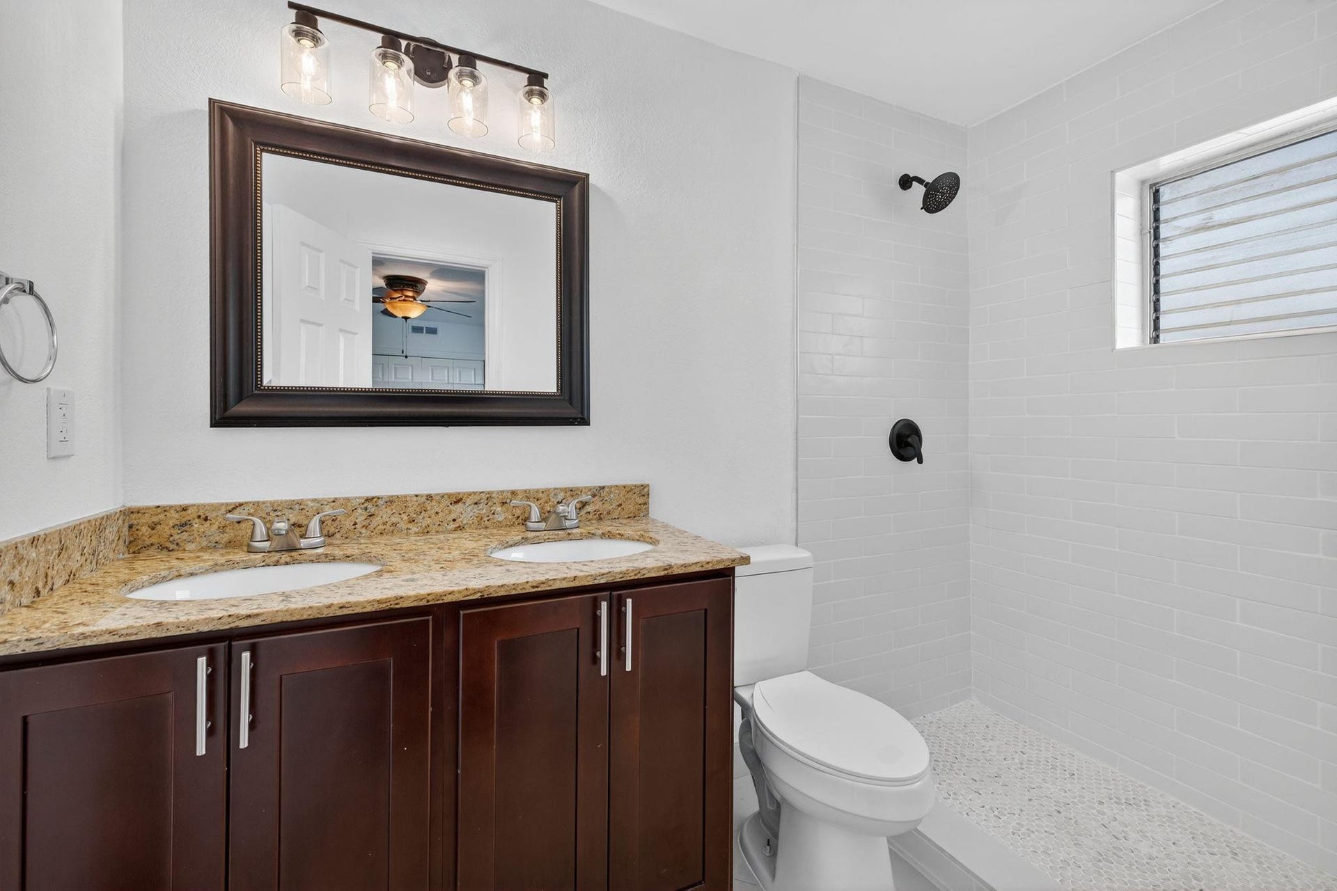 Primary Bathroom features a dual vanity sink with new toilet and modern shower design.