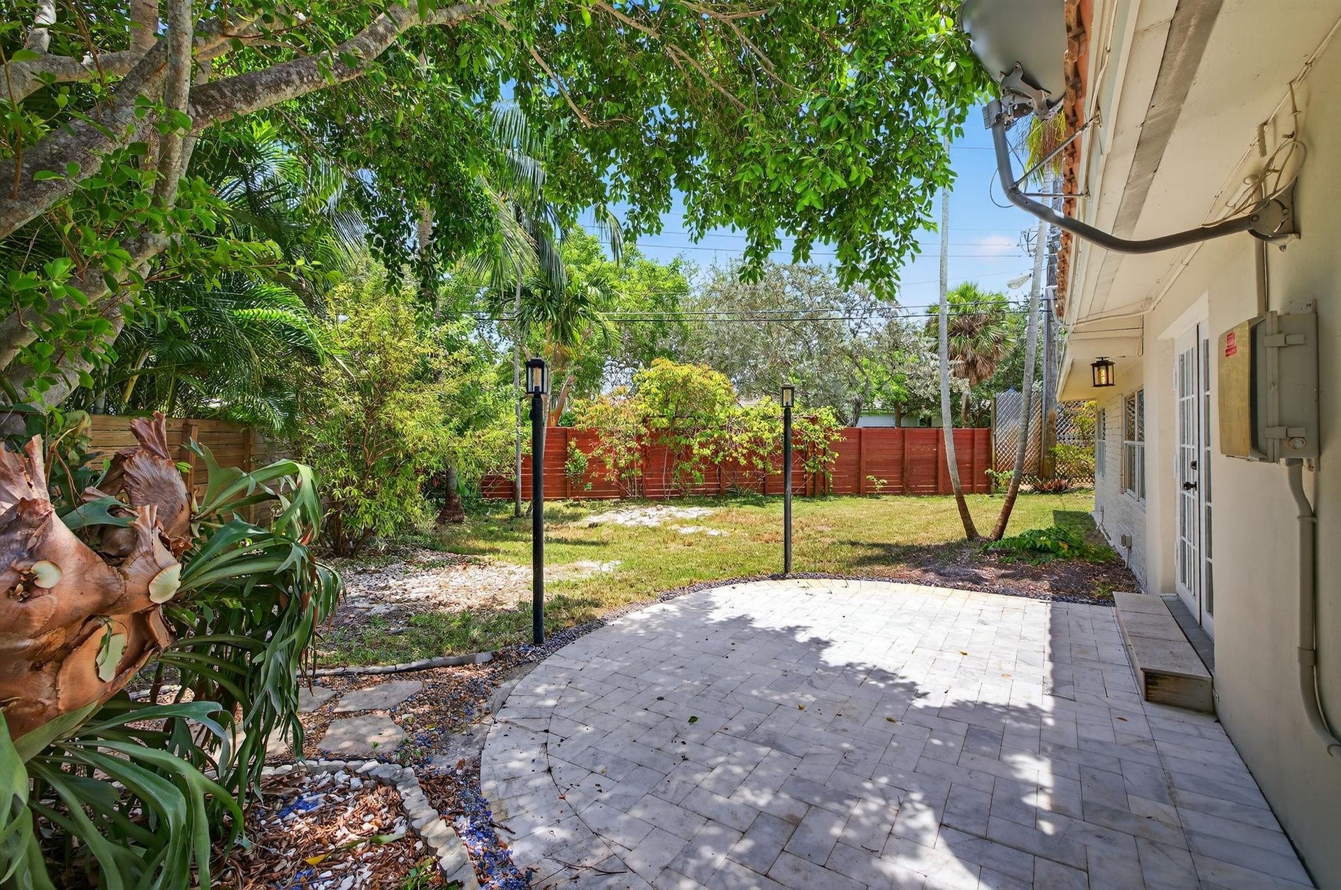Step through the French doors from the kitchen and dining room to this white marble patioperfect for seamless indoor-outdoor living in your private backyard retreat.