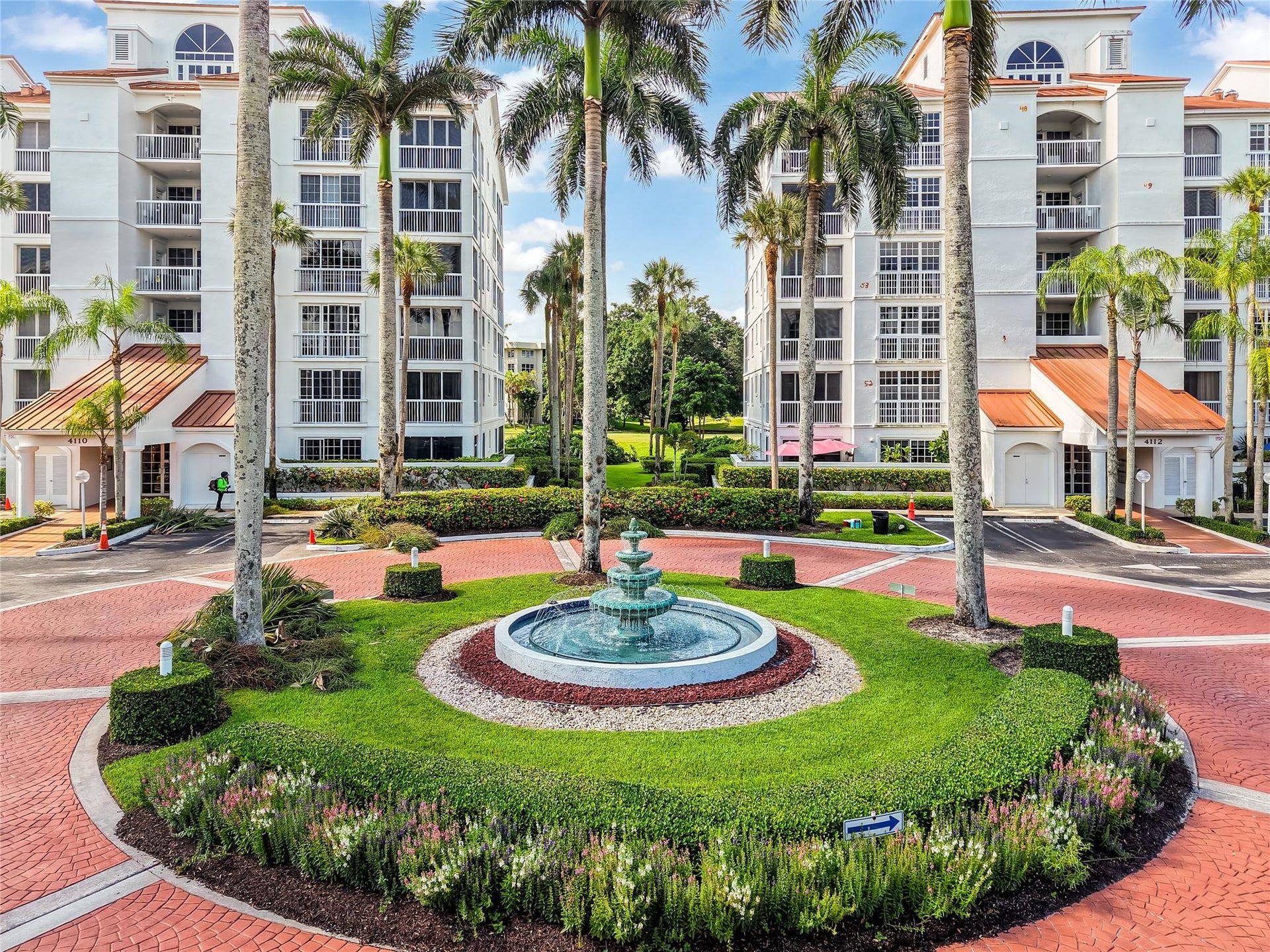 4116 W Palm Aire Drive, #166b, Pompano Beach, FL 33069 Well-maintained grounds with a central fountain, tropical landscaping, and secure building entrances offer a welcoming first impression.