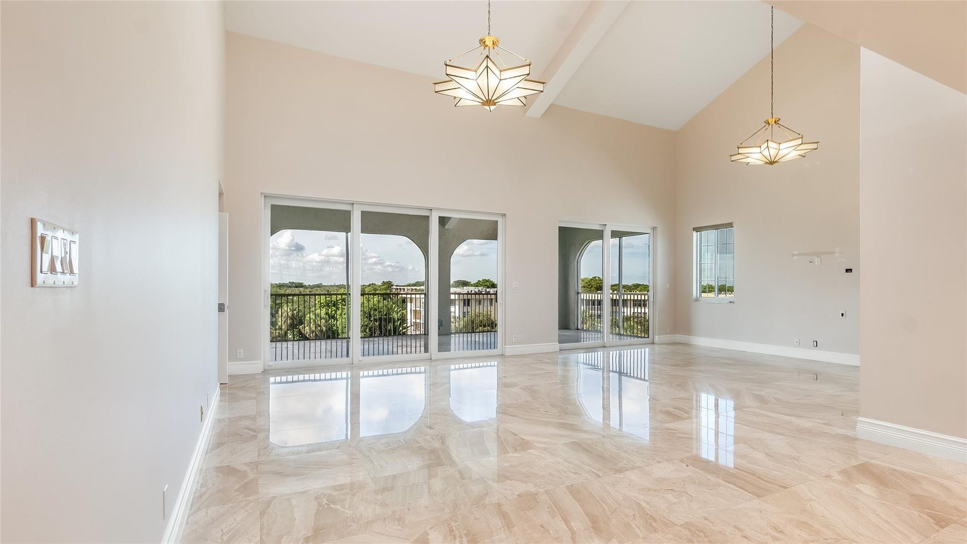 4116 W Palm Aire Drive, #166b, Pompano Beach, FL 33069 Open and airy living space with soaring ceilings, modern lighting, and access to the balcony, perfect for both relaxing and entertaining.