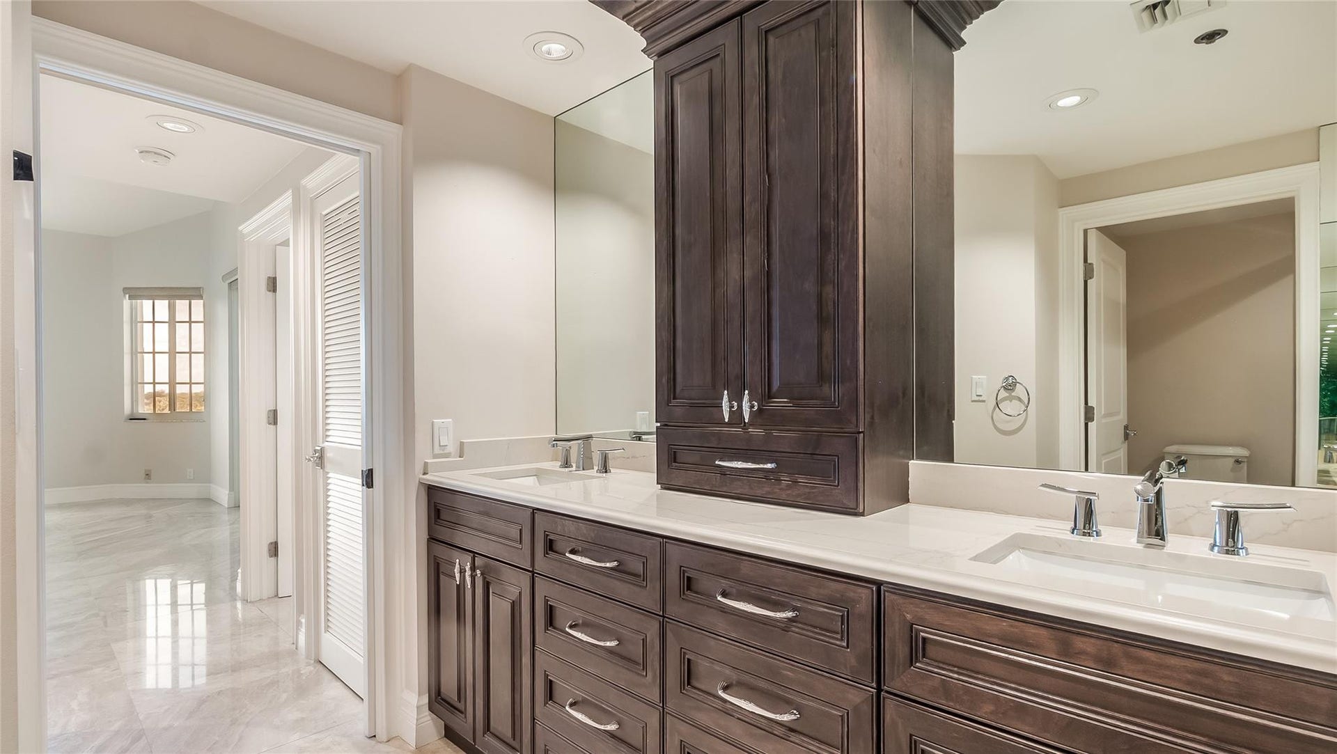 4116 W Palm Aire Drive, #166b, Pompano Beach, FL 33069 Primary Bath: Dual sinks with polished quartz countertops are anchored by custom dark wood cabinetry and full-wall mirrors for a spacious, elegant feel.