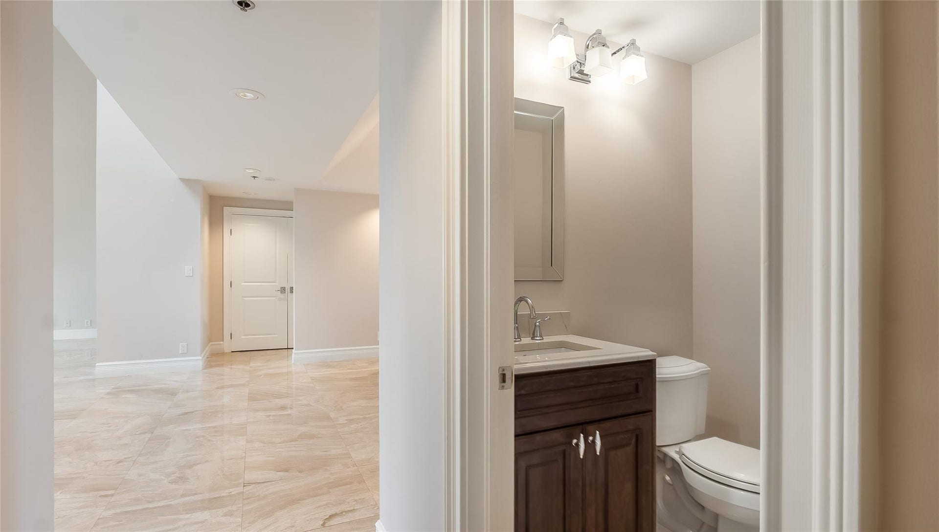 4116 W Palm Aire Drive, #166b, Pompano Beach, FL 33069 Convenient guest powder room with wood vanity, modern lighting, and quartz countertop, tucked just off the main living space.