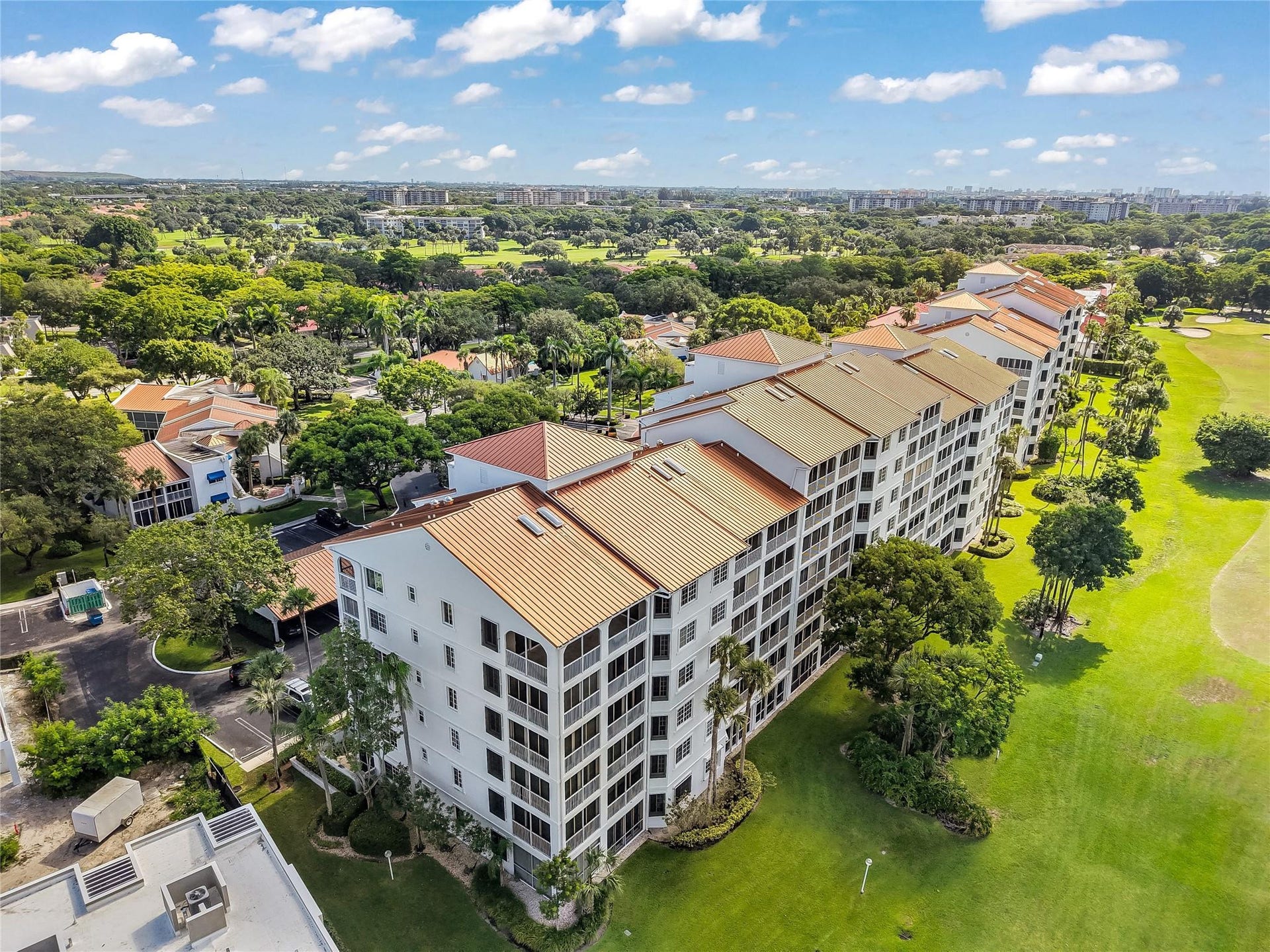 4116 W Palm Aire Drive, #166b, Pompano Beach, FL 33069 Rear-facing elevation reveals the proximity to parking and covered carports, with sweeping golf course views beyond.