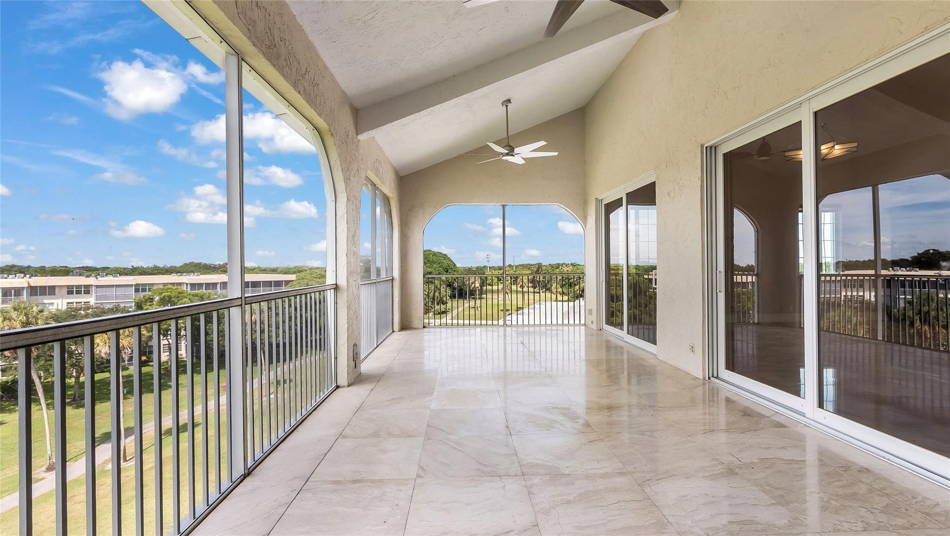 4116 W Palm Aire Drive, #166b, Pompano Beach, FL 33069 Expansive screened balcony with vaulted ceilings and dual ceiling fans, ideal for enjoying breezy afternoons or dining al fresco.