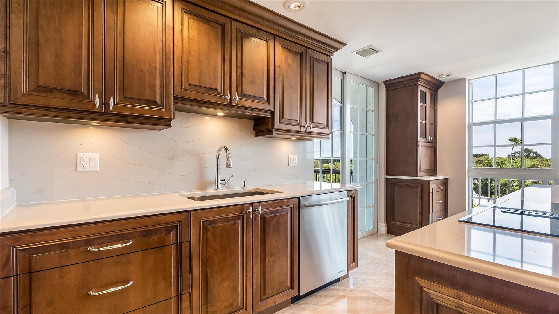 4116 W Palm Aire Drive, #166b, Pompano Beach, FL 33069 Elegant veined backsplash complements the under-cabinet lighting, stainless steel dishwasher, and large prep sink.