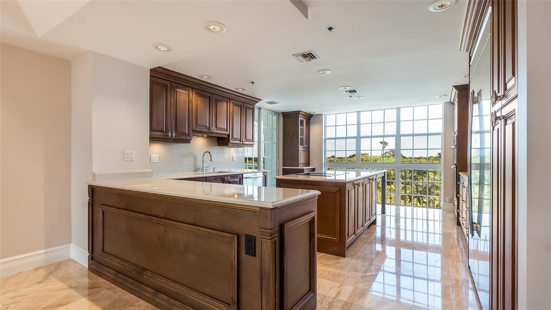4116 W Palm Aire Drive, #166b, Pompano Beach, FL 33069 Gorgeous chefs kitchen with quartz countertops, rich wood cabinetry, and dual islands for ample prep and seating space.