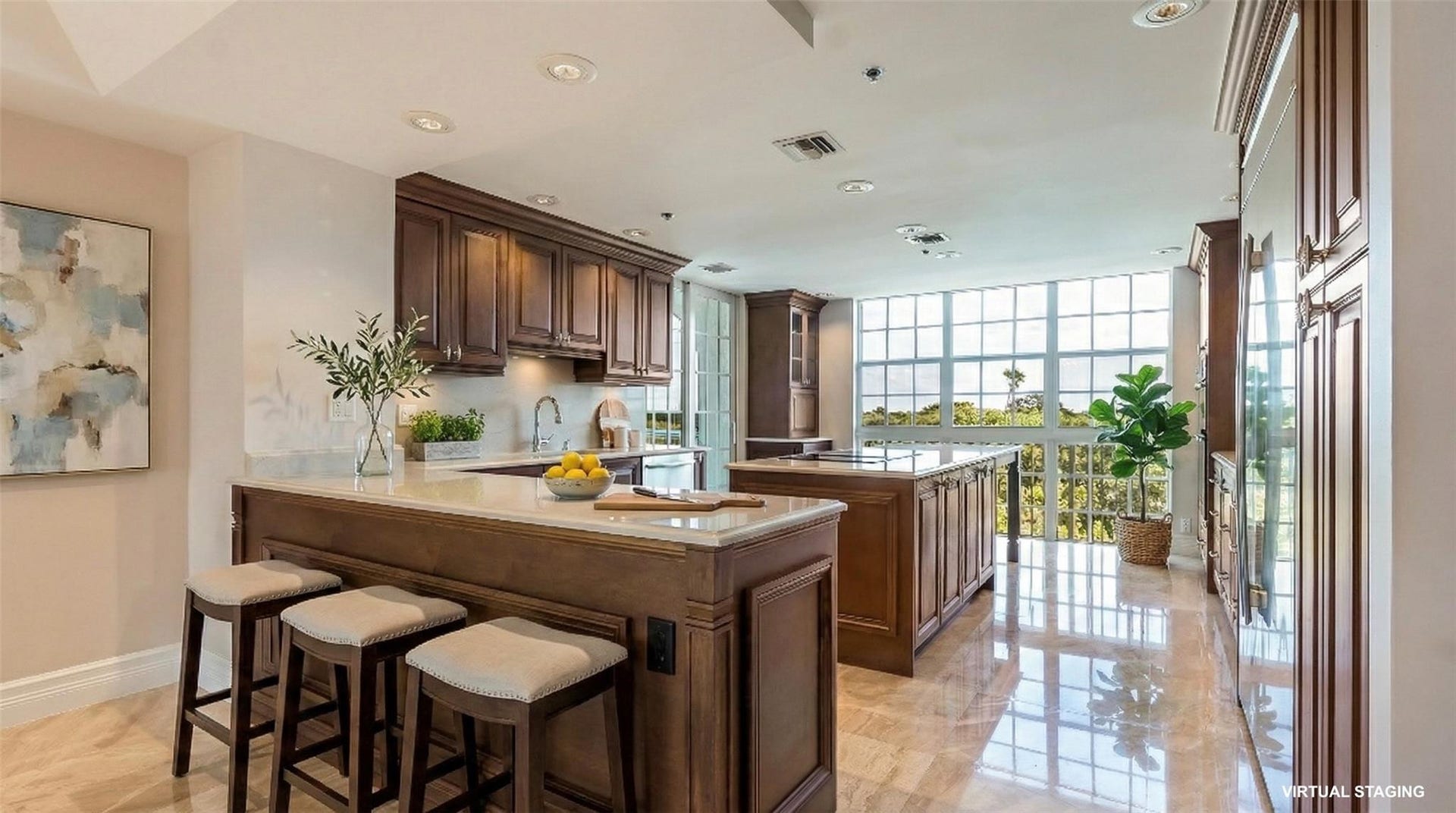 4116 W Palm Aire Drive, #166b, Pompano Beach, FL 33069 Thoughtfully designed kitchen features rich wood cabinetry, quartz countertops, and a center island, all set against a dramatic wall of windows.