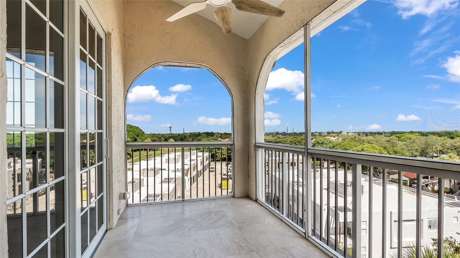 4116 W Palm Aire Drive, #166b, Pompano Beach, FL 33069 Private screened balcony with vaulted ceilings and arched openings, offering peaceful views and direct access from the guest suite.