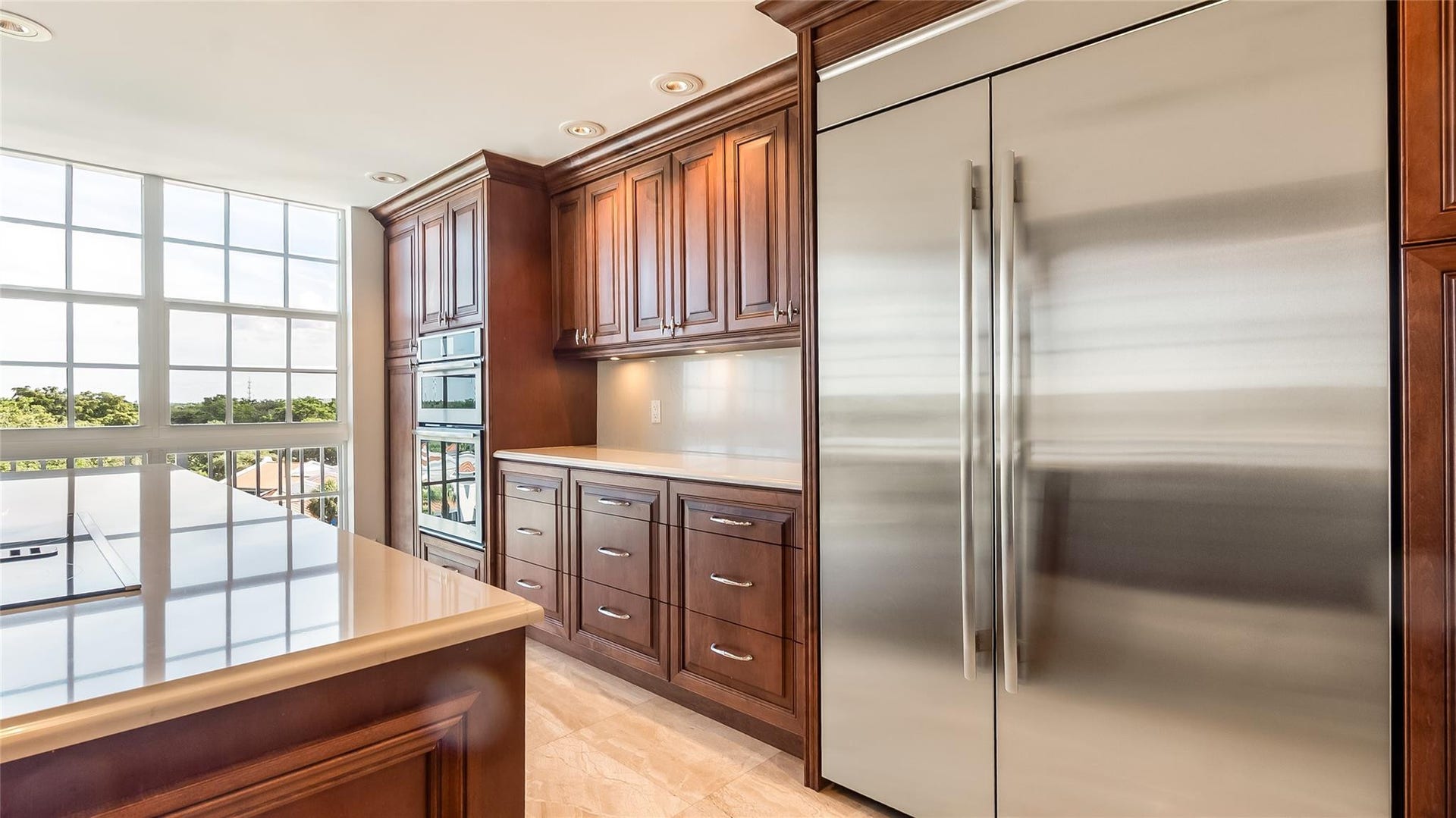 4116 W Palm Aire Drive, #166b, Pompano Beach, FL 33069 Built-in stainless steel refrigerator and double ovens are set into custom cabinetry, offering high-end style and function.