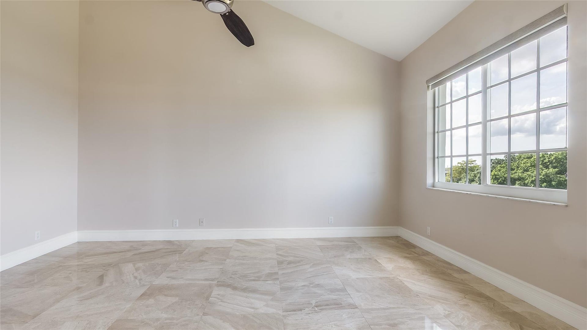 4116 W Palm Aire Drive, #166b, Pompano Beach, FL 33069 Primary Bed: Vaulted ceilings and expansive windows fill the space with natural light, complemented by polished tile flooring and private balcony access.