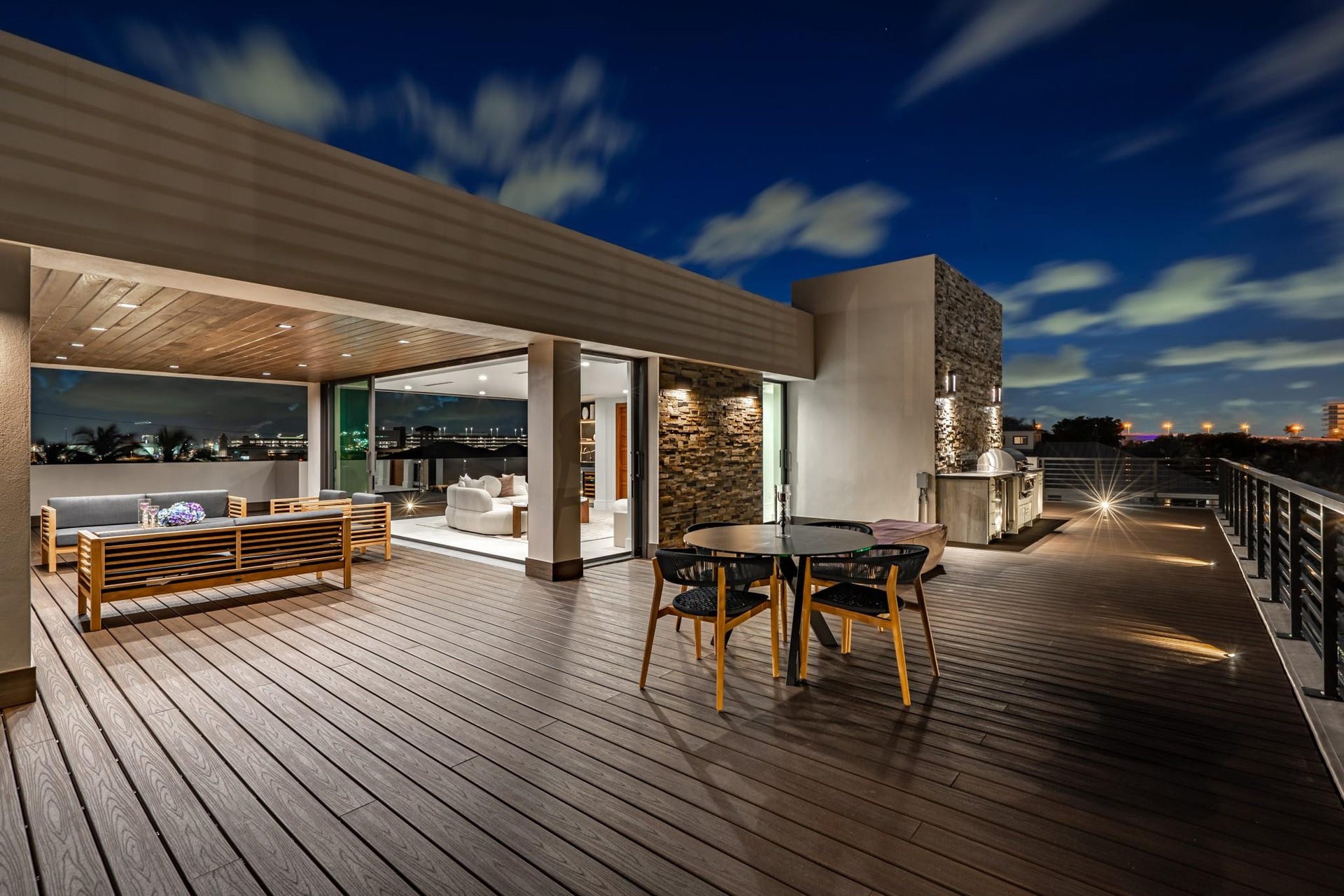 2000 Harbourview Drive, Fort Lauderdale, FL 33316 A dramatic evening terrace showcasing expansive decking, warm ambient lighting, and multiple lounge areas designed for effortless entertaining. Elevated and atmospheric, this stunning outdoor space captures the essence of modern luxury under the night sky.