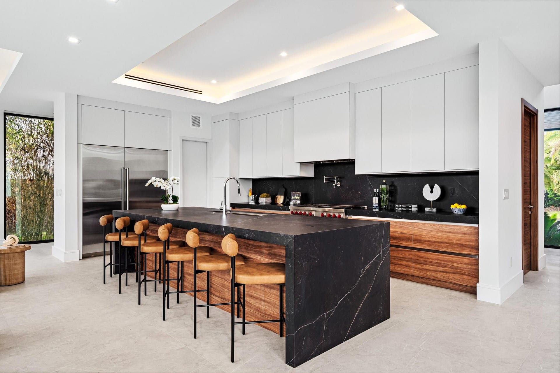 2000 Harbourview Drive, Fort Lauderdale, FL 33316 A showstopping chefs kitchen anchored by a dramatic waterfall-edge island, rich wood cabinetry, and sleek black stone accents. Expansive and impeccably designed, this contemporary culinary space is crafted for elevated entertaining and everyday luxury.