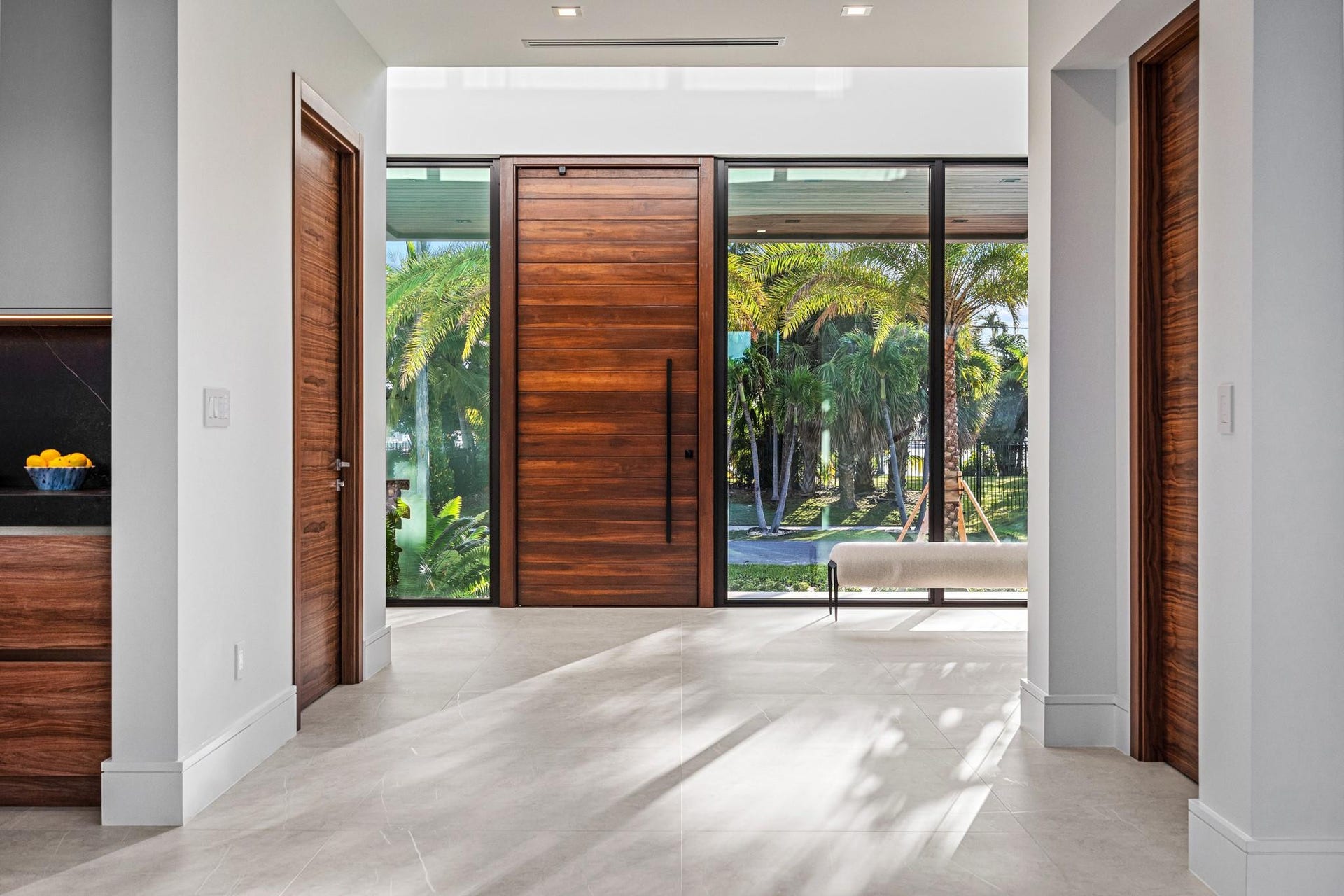 2000 Harbourview Drive, Fort Lauderdale, FL 33316 A grand modern entry framed by warm wood accents, floor-to-ceiling glass, and abundant natural light. Clean architectural lines and a dramatic pivot door create a striking first impression of contemporary sophistication.